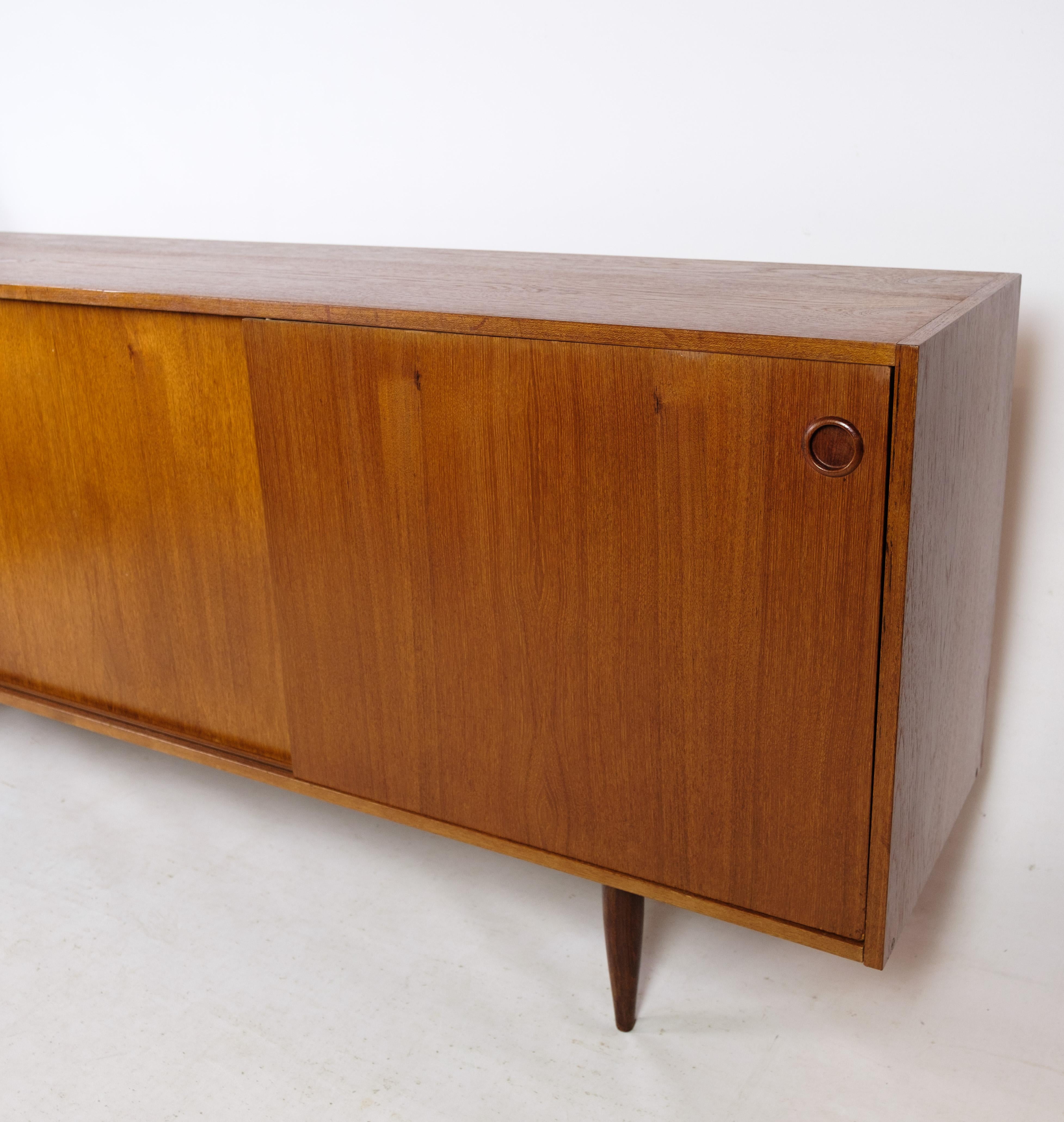 This sideboard is an exemplary piece of Danish design from the 1960s, crafted in the characteristic teak wood structure that is so sought after for its durability and beauty. With its clean lines and elegant proportions, the sideboard exudes a