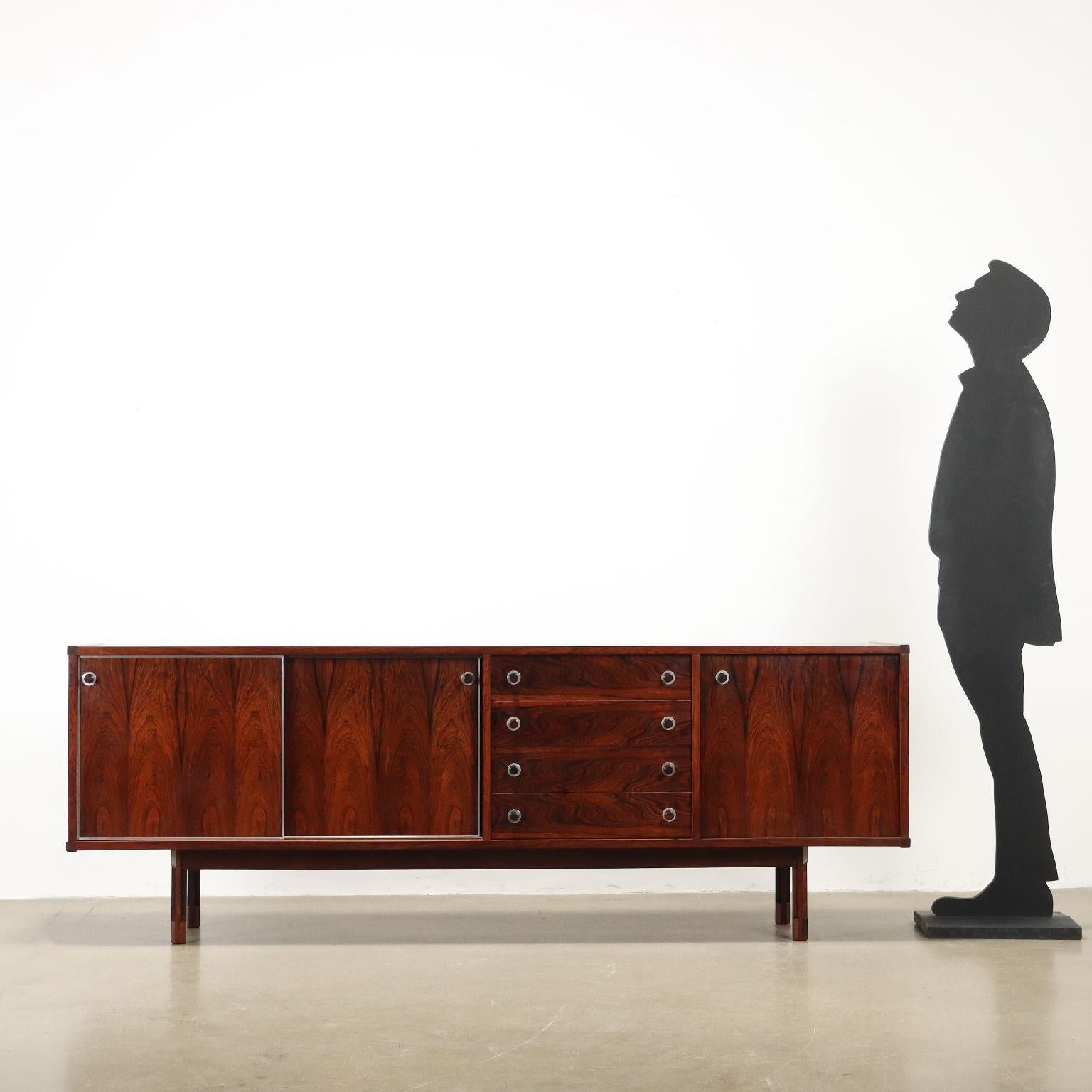 Superbe buffet qui peut également être utilisé comme pièce maîtresse, avec une paire de portes coulissantes, une porte latérale à charnières et des tiroirs apparents, bois plaqué Jacaranda, profilés en aluminium. Entièrement restauré.