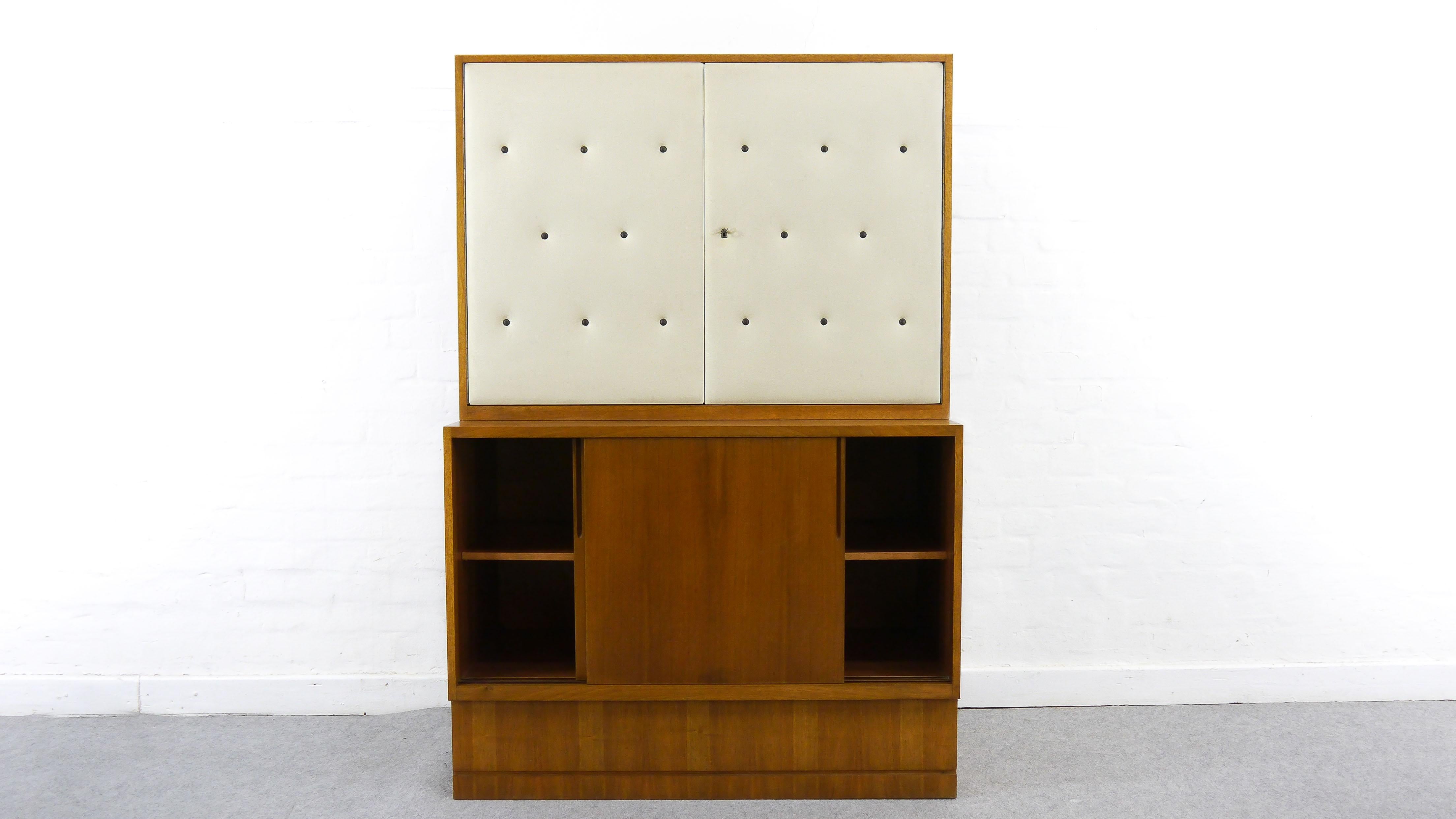Bauhaus-pupil Franz Ehrlich designed this furniture series in the early fifties for the VEB Deutsche Werkstätten Hellerau. Barelement with 2 doors, mirrored and with stone/glass inside. Sideboard with two sliding doors.
Measurements: Sideboard: W