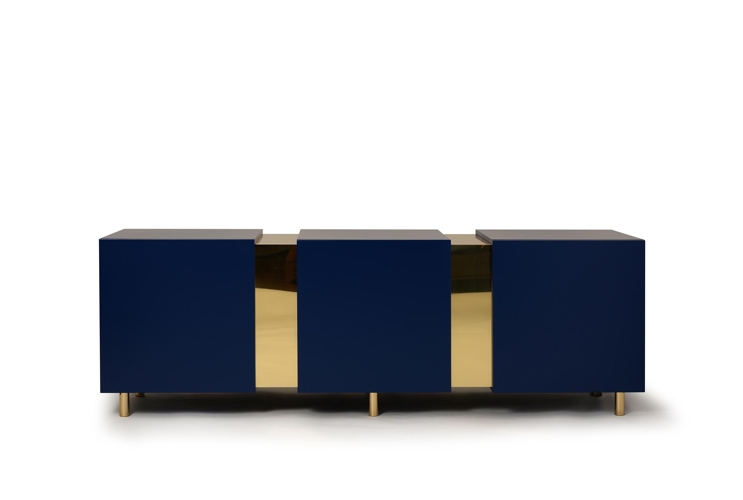 Eunduetrè is a low storage system which punctuates the space and plays with contrasting effects. Extremely simple in its geometric shapes, this sideboard/credenza alternates colorful cubes in matt lacquered wood, with sections of bent brass sheet