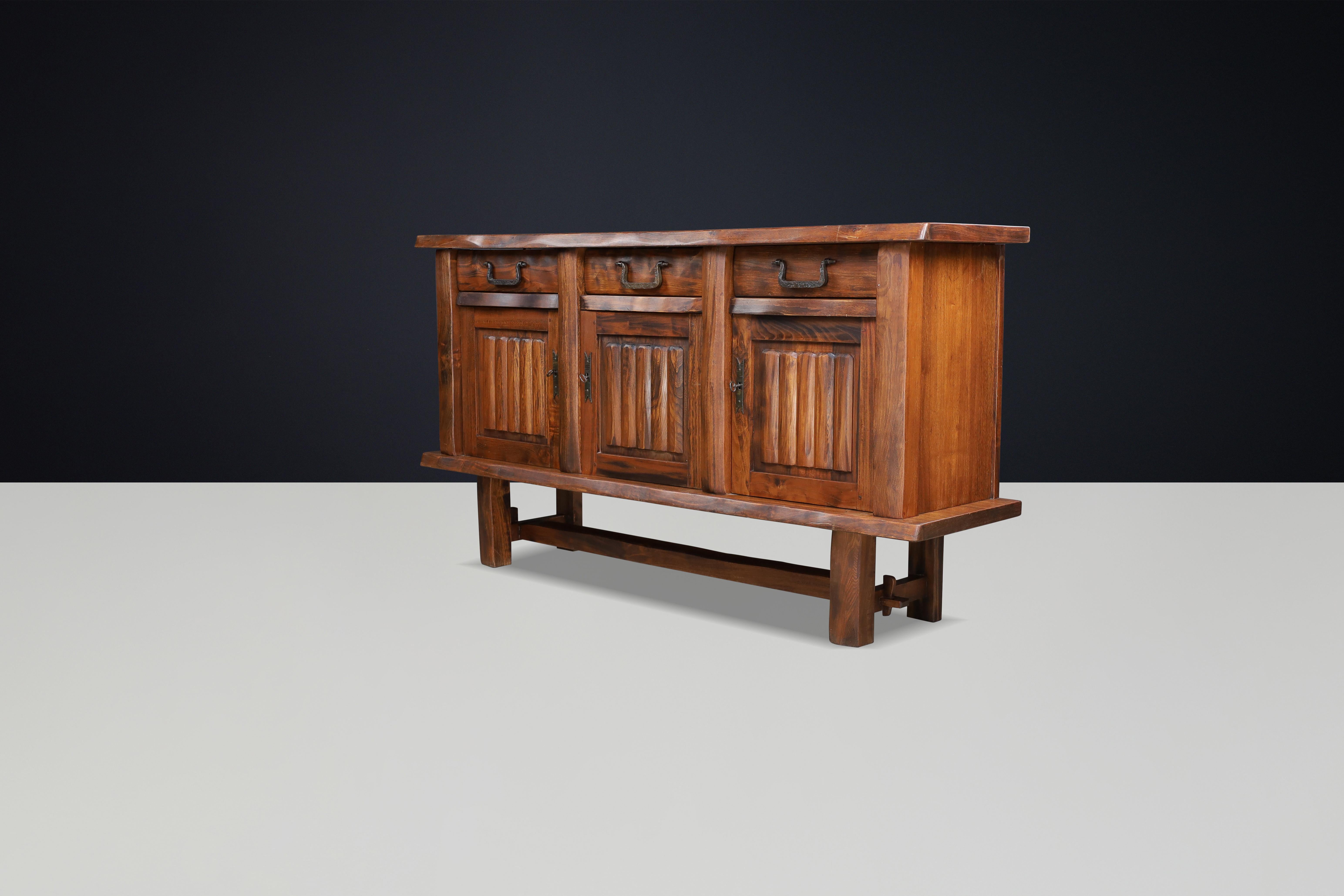 Sideboard in Elm by Olavi Hänninen for Mikko Nupponen, Finland, 1958

This large credenza is crafted from solid elm and features a simplified design that highlights the natural beauty and grain of the wood. It includes three doors, shelves, and