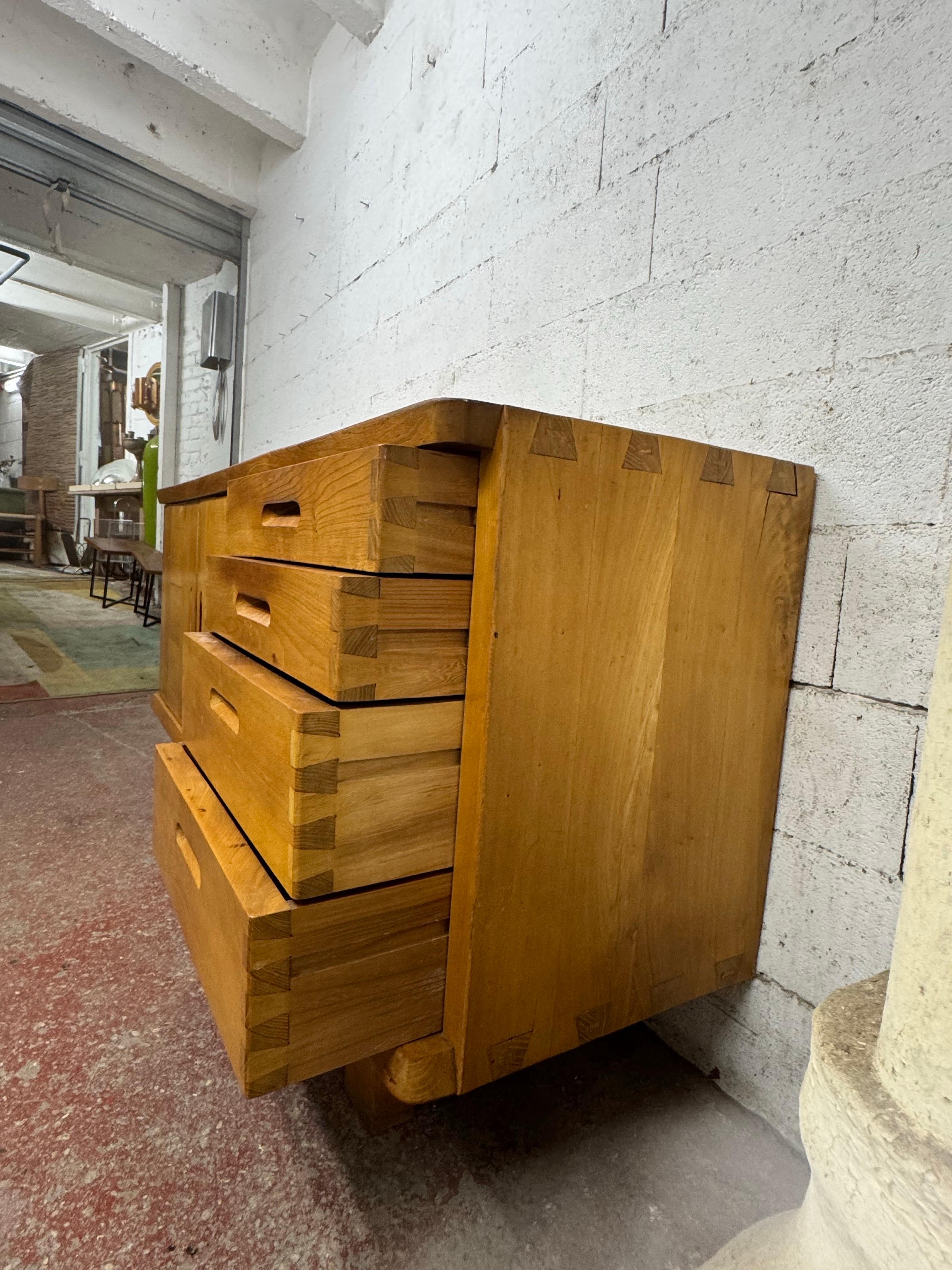 questa credenza è una prima edizione di Maison Regain del 1970 circa, tutta in olmo con due ante a sinistra e quattro cassetti a destra
