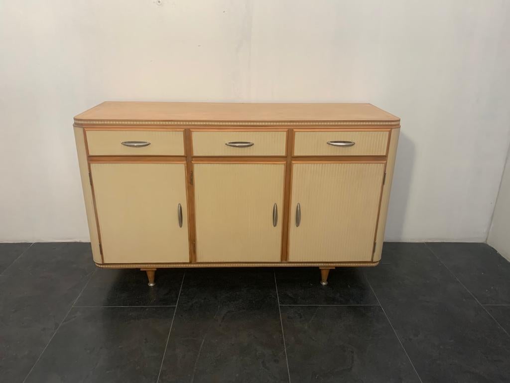 Sideboard Italy 50's. Beechwood construction with honeycomb structure, internally and on the back covered in masonite, on the top in linoleum. The body, the doors, the front of the drawers are finished in relief with breadstick groove, covered in
