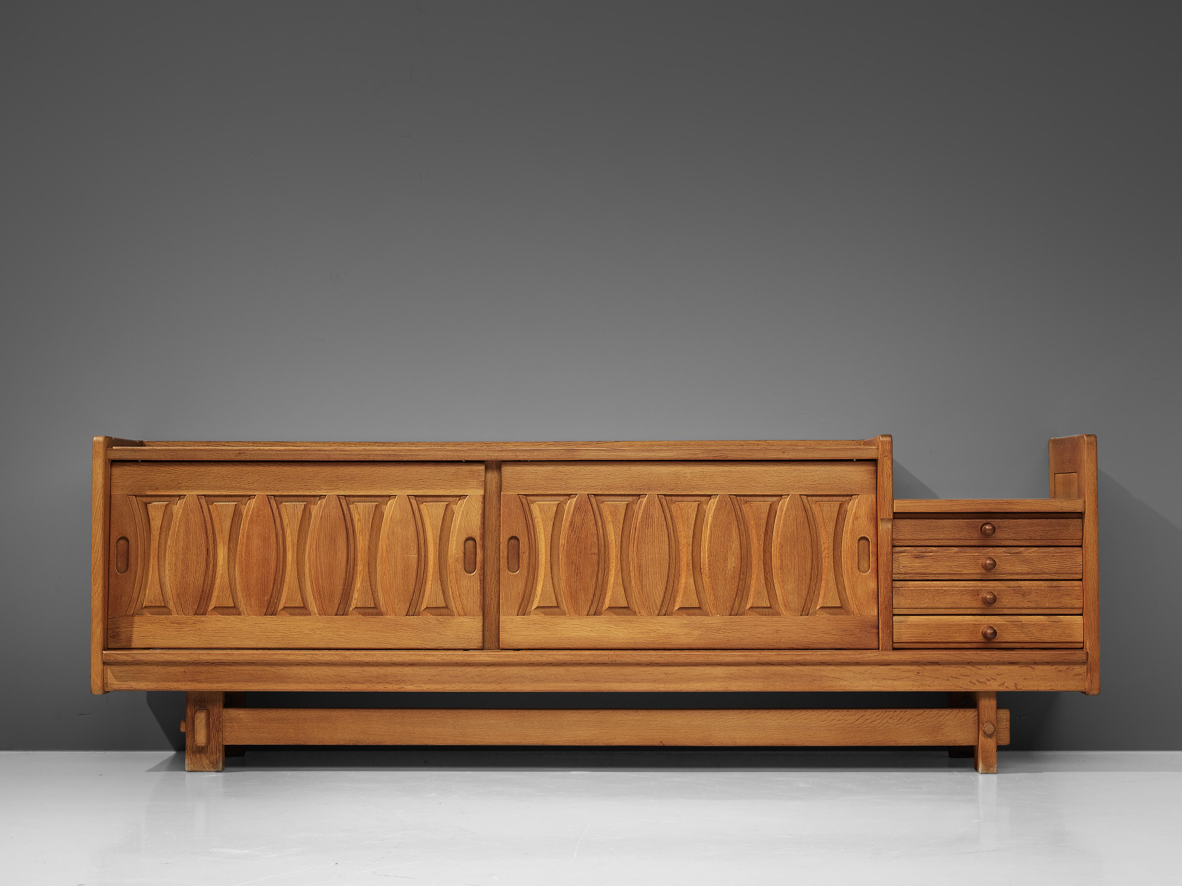 Guillerme et Chambron, sideboard, oak, ceramics, France, 1960s

Credenza in oak by French designers Guillerme & Chambron. This sideboard is equipped with two sliding doors and a set of drawers. The front of the sideboard is beautifully detailed with