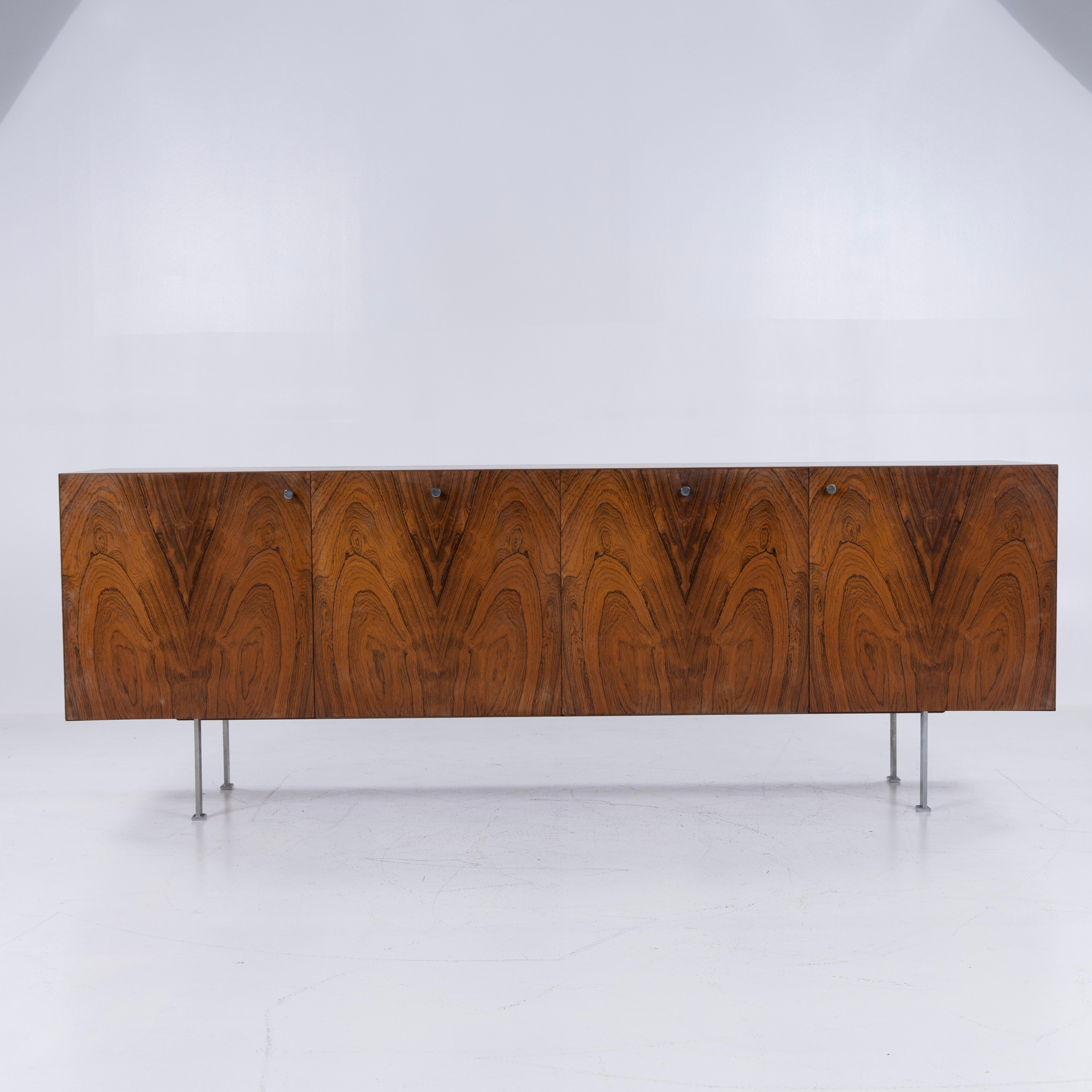Buffet en palissandre brésilien avec structure en acier chromé. Intérieur en chêne avec panneaux extensibles.
Conçu par Poul Nørreklit et fabriqué par Sigurd Hansen Møbelfabrik.
