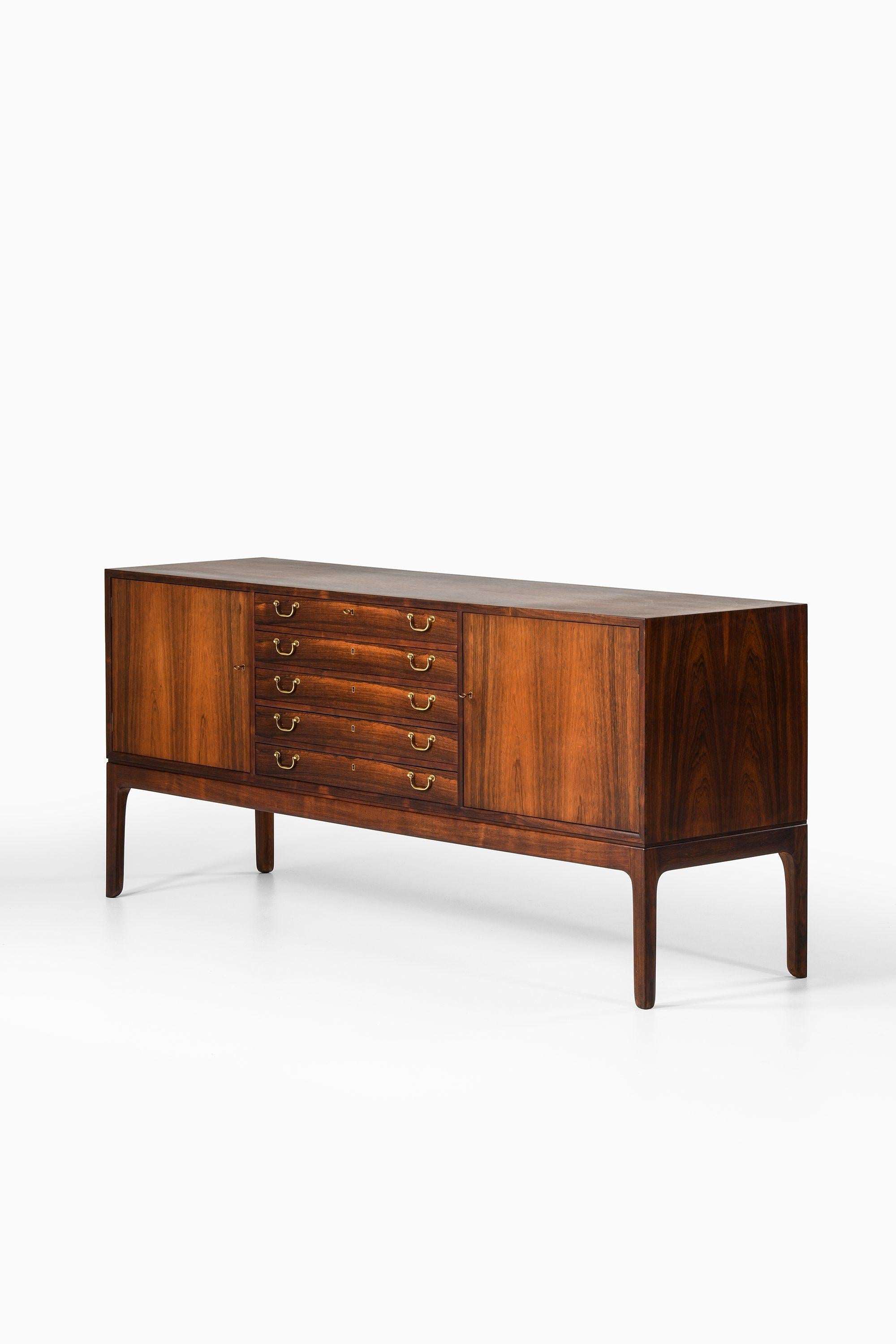 Sideboard in Rosewood and brass by Ole Wanscher

Additional Information:
Material: Rosewood, brass
Style: Mid century, Scandinavian
Produced by cabinetmaker A.J. Iversen in Denmark
Dimensions (W x D x H): 196 x 54 x 86 cm
Condition: Good vintage