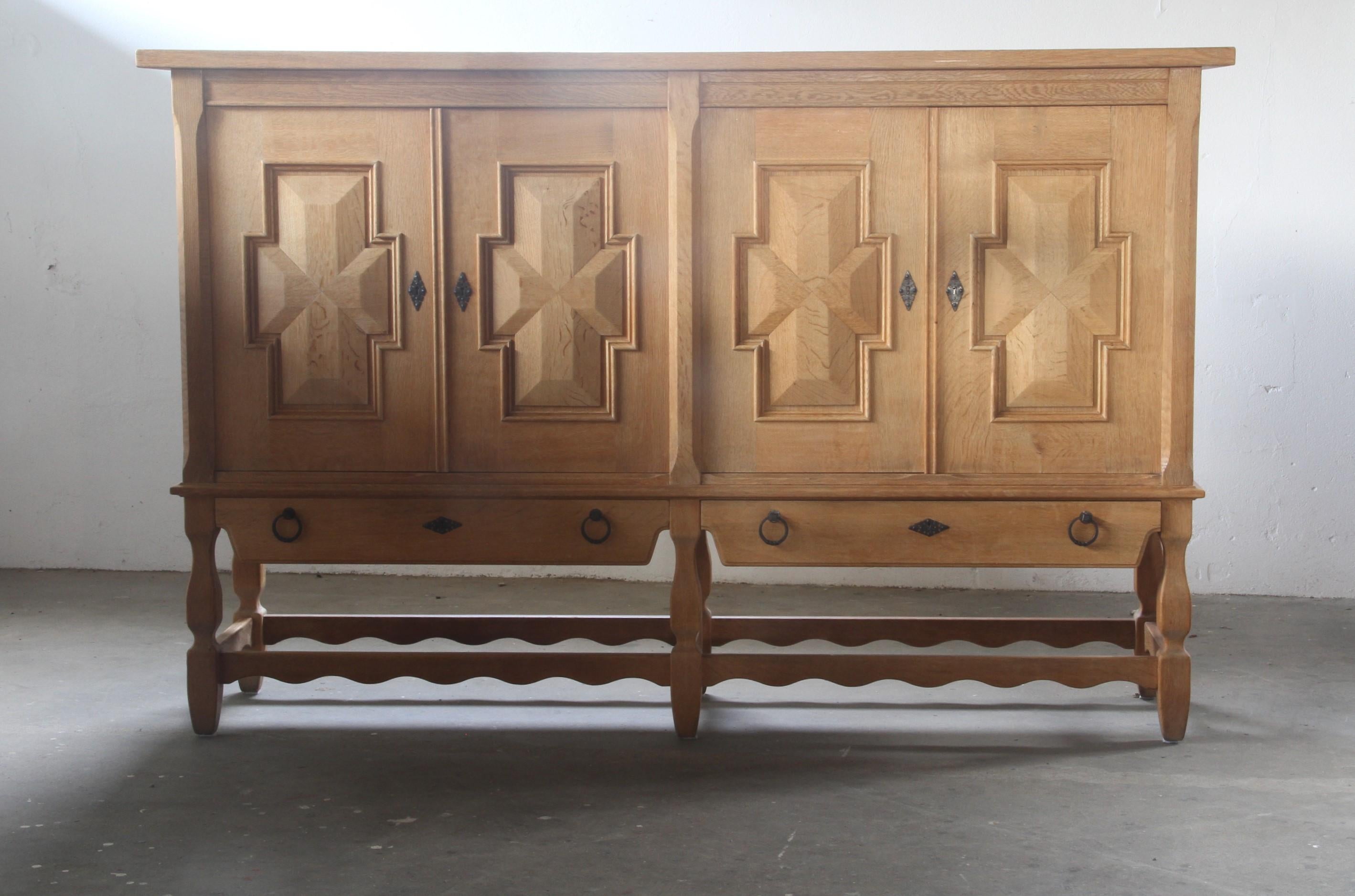 A majestic sideboard crafted in the style and quality of Henning Kjærnulf, this piece showcases exceptional craftsmanship in every detail. Made from solid oak, it features an adjustable shelving system that uses beautifully crafted corner holes in