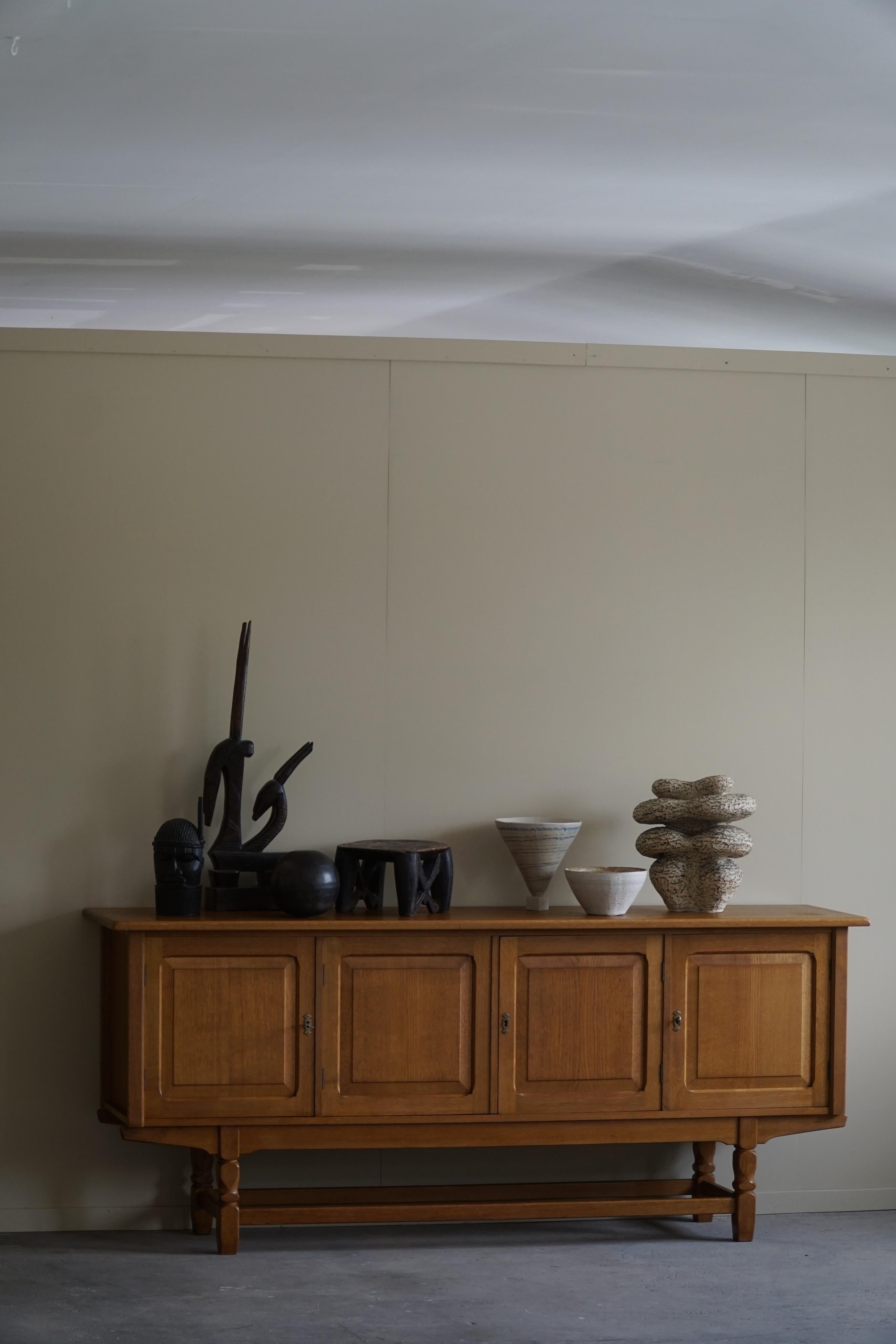Beautiful low classic sideboard / cabinet in solid oak with plenty of storage space. Made by a Danish cabinetmaker in the 1960s. This piece is in a great vintage condition, with few signs of wear.

This brutalist object will fit into many interior