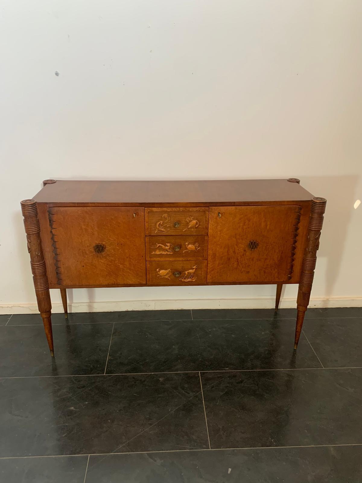 Oak and maple burl sideboard, widely popular in the 1950s.
Unique in its kind, with multiple design details and exclusive finishes that complemented each other, making the piece harmonious and truly one of a kind.
The conical legs are sculpted at
