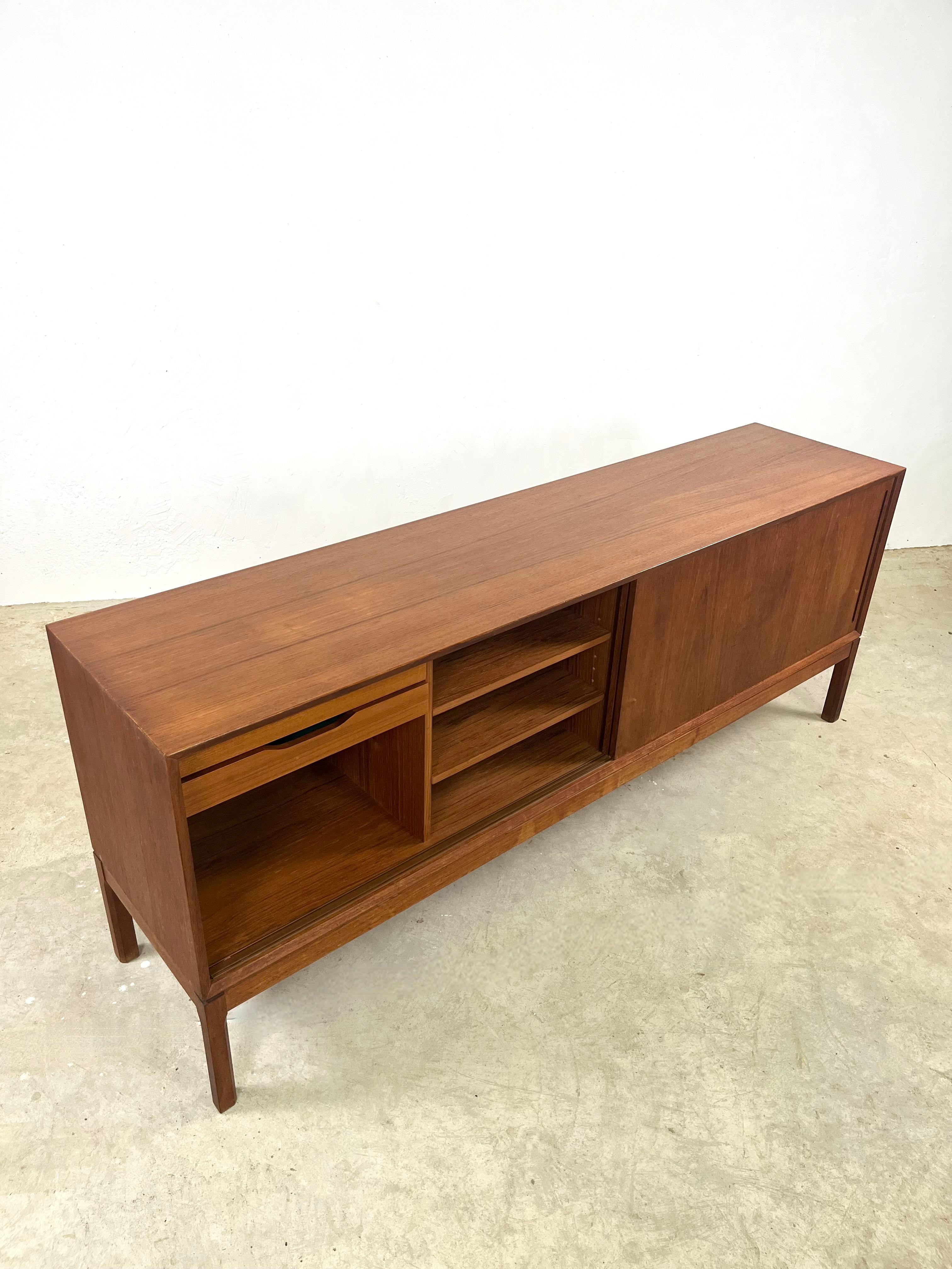 Magnificent sideboard attributed to Aksel Kjersgaard in the 1960s in Denmark.
This magnificent teak sideboard features two sliding doors housing two large compartments. In the left-hand sideboard, you can see shelves and two drawers with splendid