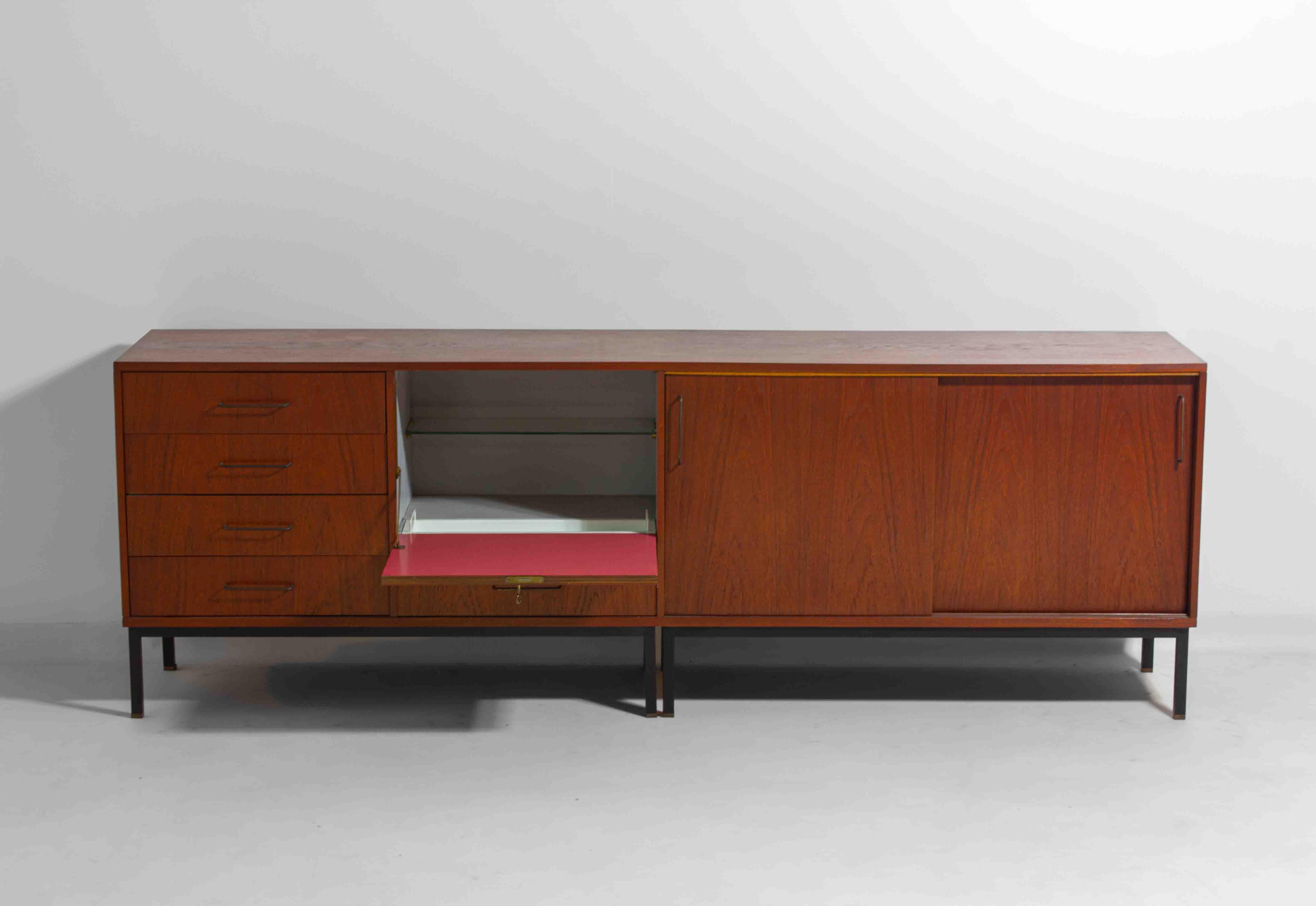 Questa bellissima credenza in teak, appoggiata su un'elegante base in metallo nero, è un incredibile esempio del modernismo belga degli anni '60. È stata progettata e prodotta da un produttore di mobili locale, A. Clement Wulput, per 