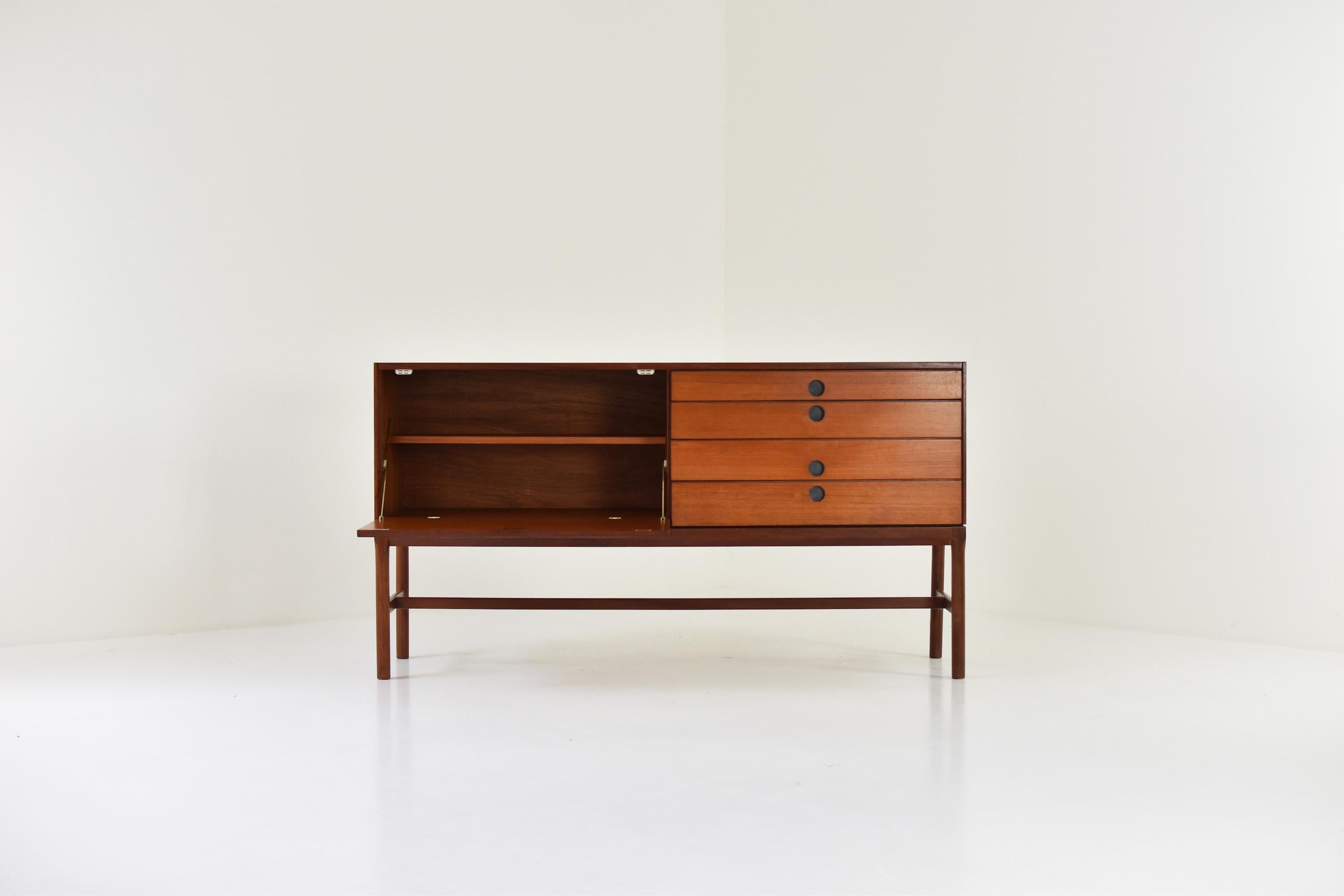 Rarely seen sideboard in teak by Philip Hussey for White & Newton, United Kingdom 1969. This low sideboard has a drop down door on the left and a series of drawers on the right. Good original condition with only minor wear. Labeled.