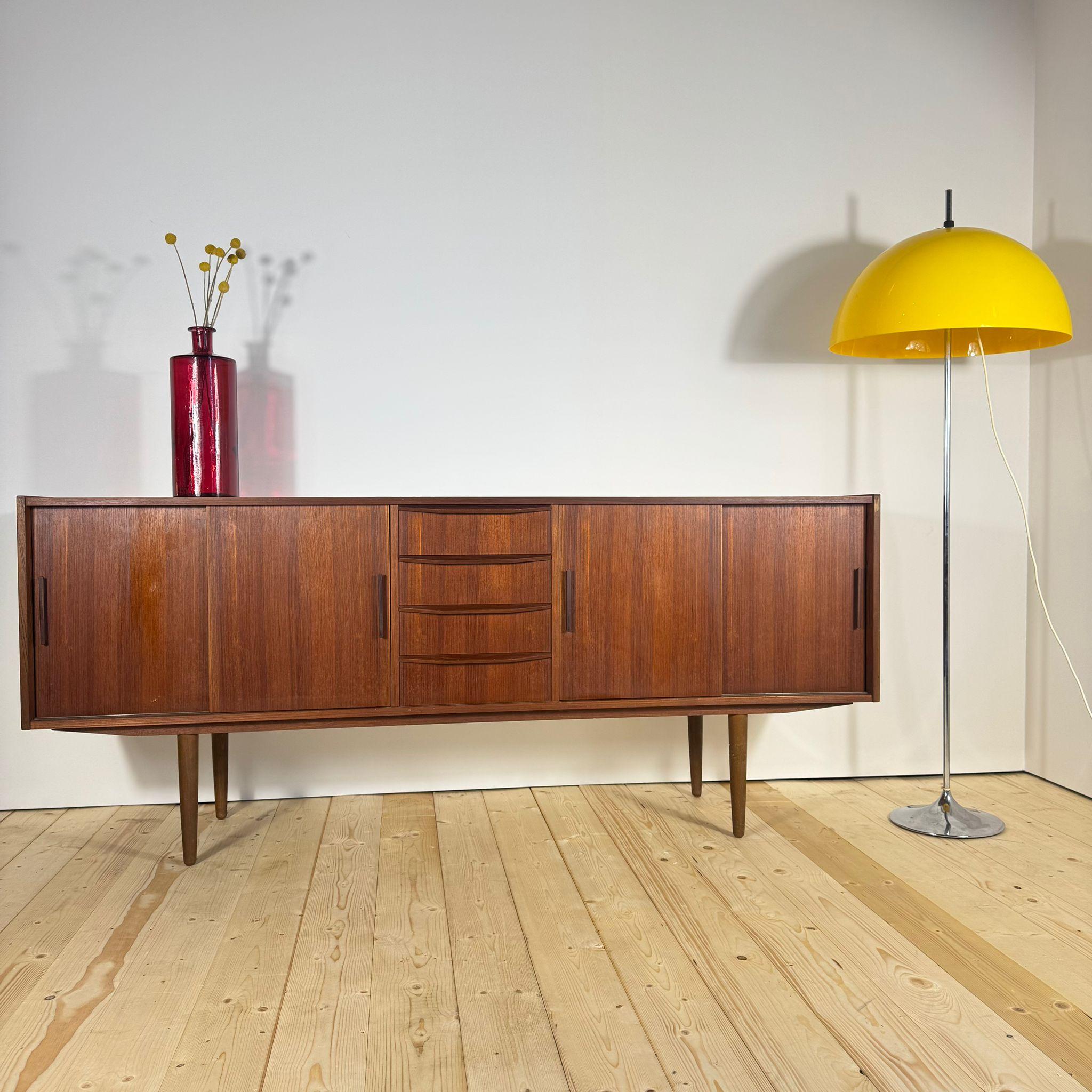 Questo sideboard in teak impiallacciato rappresenta uno dei simboli più riconoscibili del design scandinavo degli anni Sessanta: linee pulite, funzionalità intelligente e una qualità materica che dona calore immediato all’ambiente. Le ante