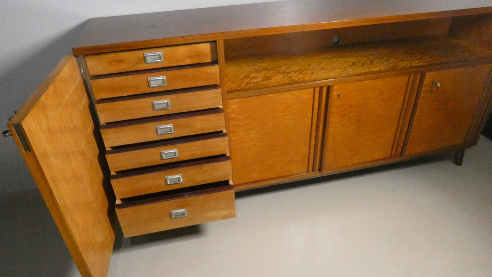 Sideboard made of solid Teak handcrafted in the 1970s in Italy. Very distinctive is the drawer compartment (with 7 drawers, the last one at the bottom of which is more capacious) with steel handles and a full-hinged door.

In addition to the