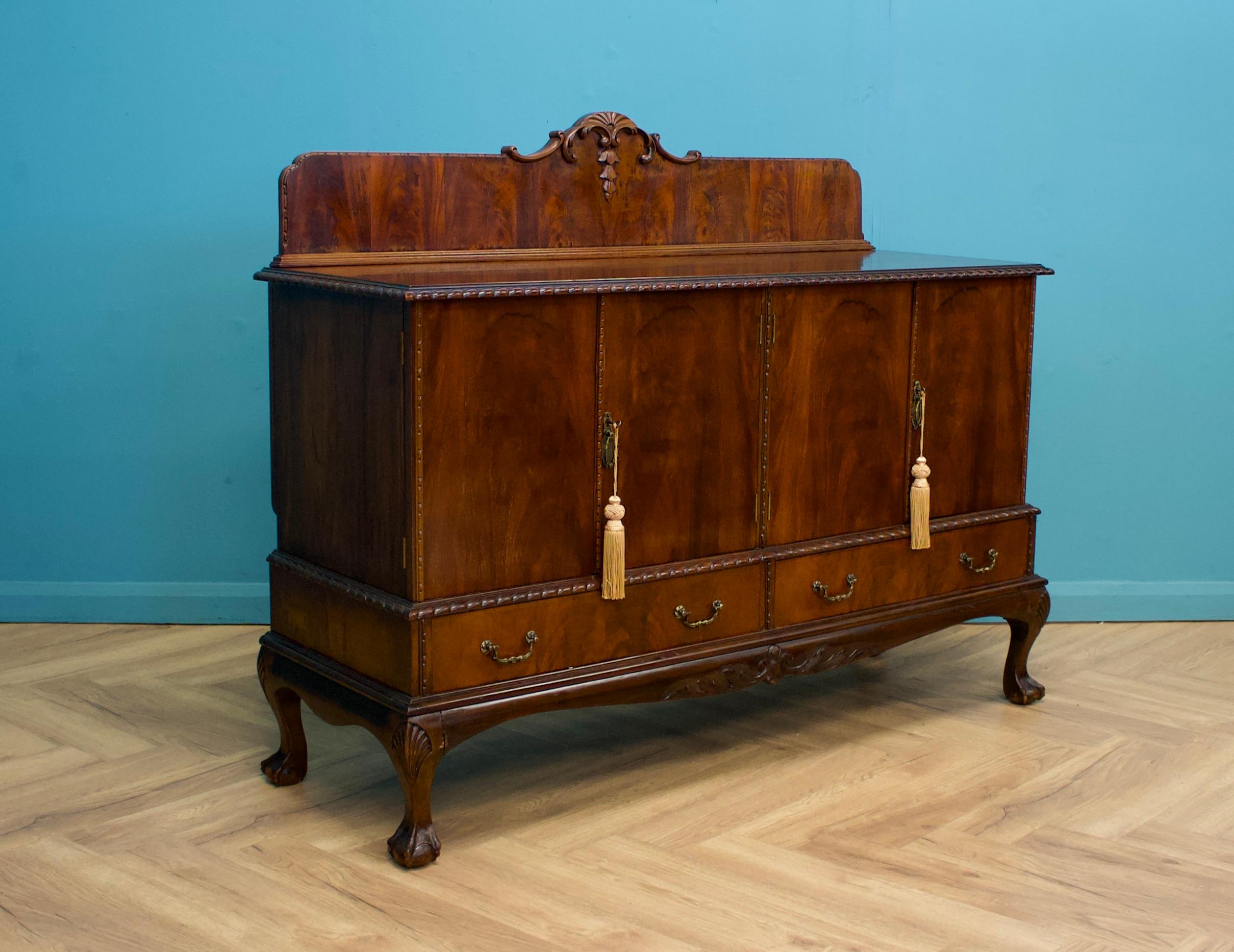 This high-quality mahogany sideboard, circa 1930s
In the manner of Chippendale
Featuring two cupboards and two drawers


Height to the top of the plinth is 124 cm