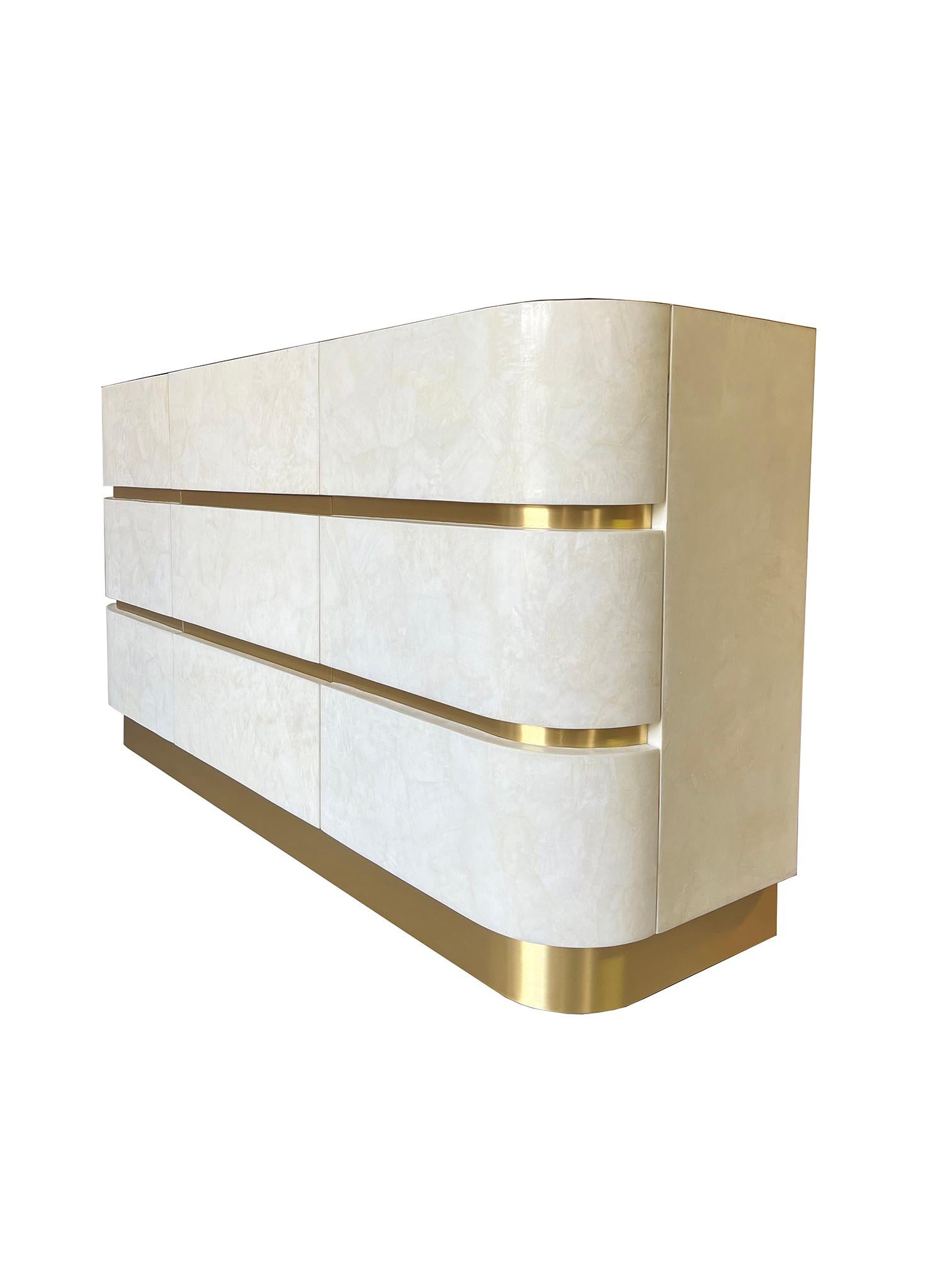 This cabinet has 2 doors and three drawers in the center, and it is made of white rock crystal marquetry with brass trims.
The base is in brushed brass.

The interior is in light oak veneer.
 
The dimensions of this piece are 66.9
