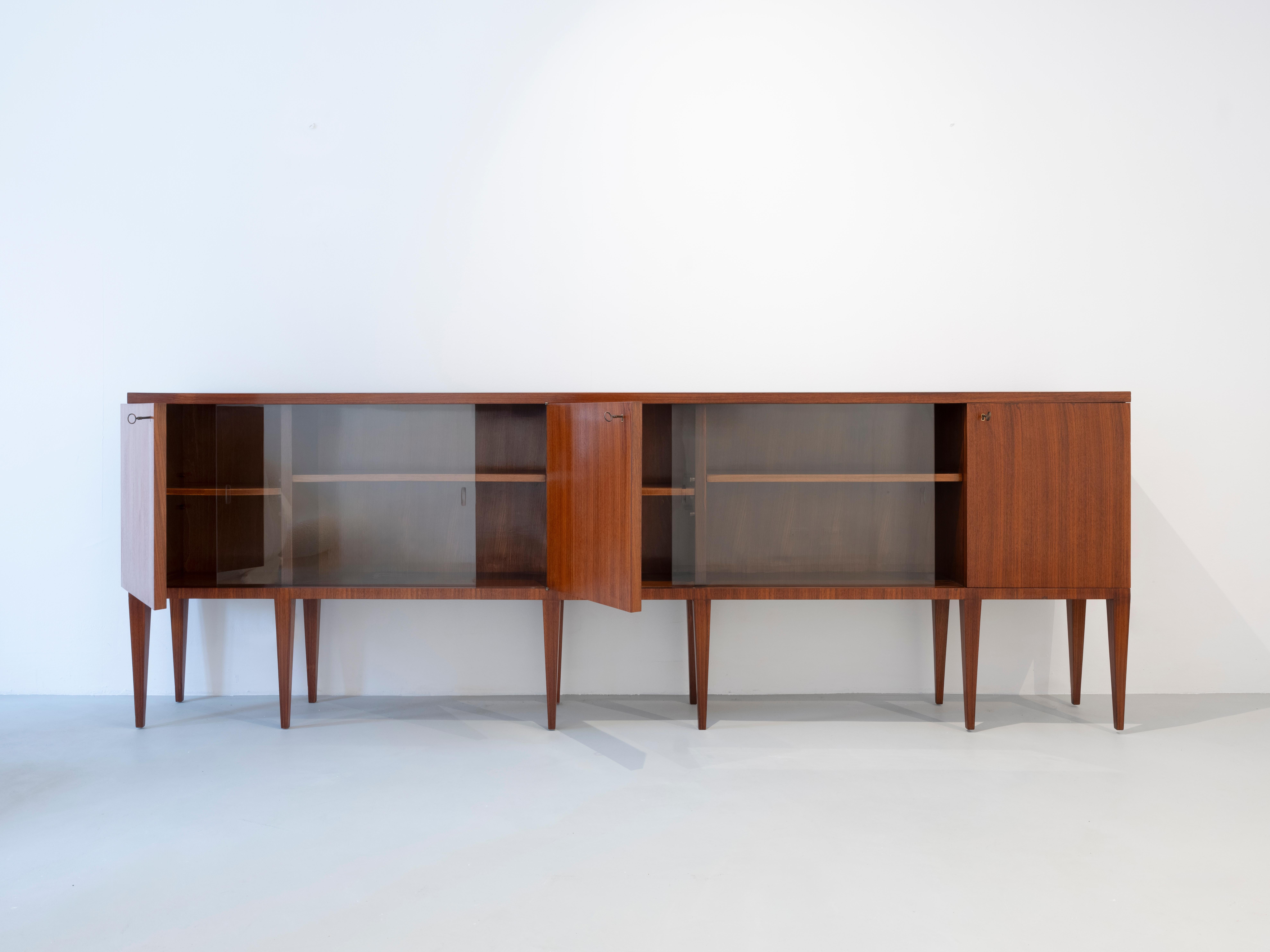 Gio Ponti large sideboard in wood with two sliding doors in glass, Italian manufacture from the 1950s.

The sideboard comes with the Gio Ponti archives certificate.

Gio Ponti (Milan, 1891 - Milan, 1979) was an Italian architect, designer and