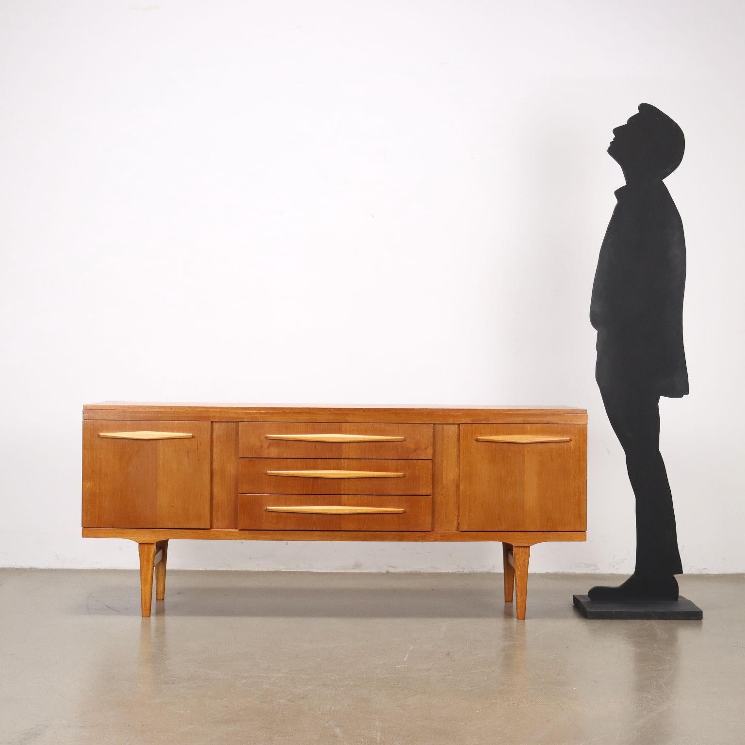 Buffet avec portes latérales à charnières et tiroirs centraux visibles, poignées en bois spéciales, bois plaqué teck. Soigneusement et entièrement restauré par notre atelier. 