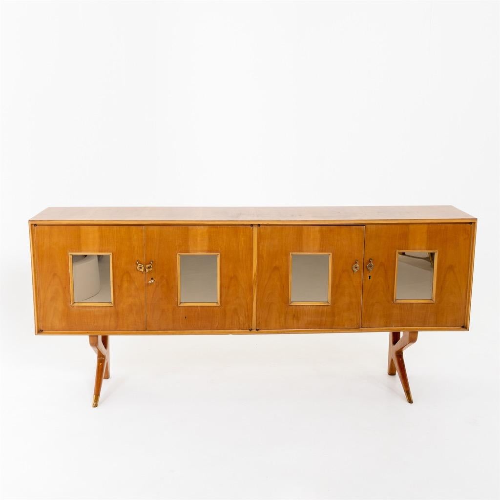 Four-door sideboard with mirrored doors standing on tapering legs with brass sabots.