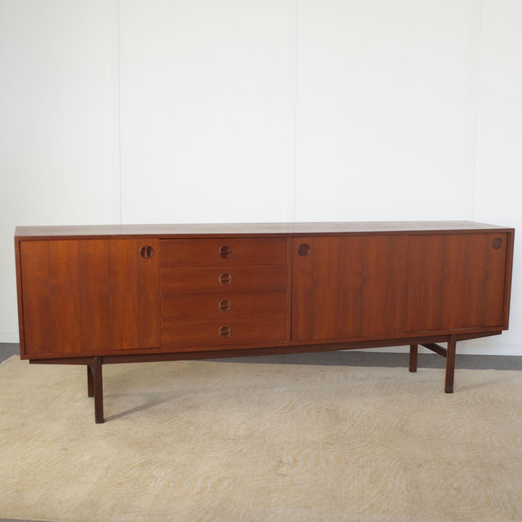 Walnut wood sideboard composed of four compartments one with 4 drawers the other three containing doors two of which slide in the style of designer Georges Nelson, 1960s production.