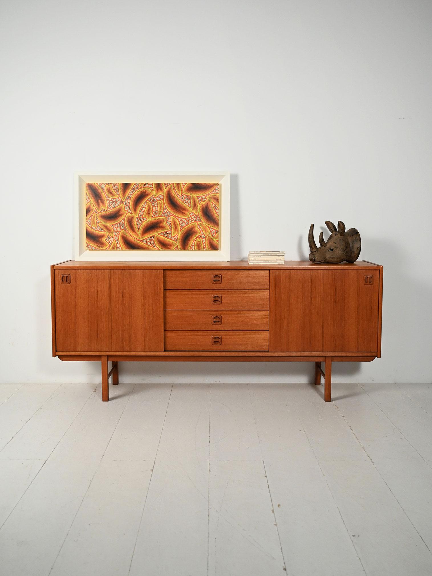 Sideboard “Korsør” di IKEA in teak, produzione 1967, due vani con mensole e ante scorrevoli, cassetti centrali con maniglie scavate.

Linee sobrie e proporzioni equilibrate per il sideboard “Korsør” di IKEA in teak, prodotto nel 1967. Ai lati, due