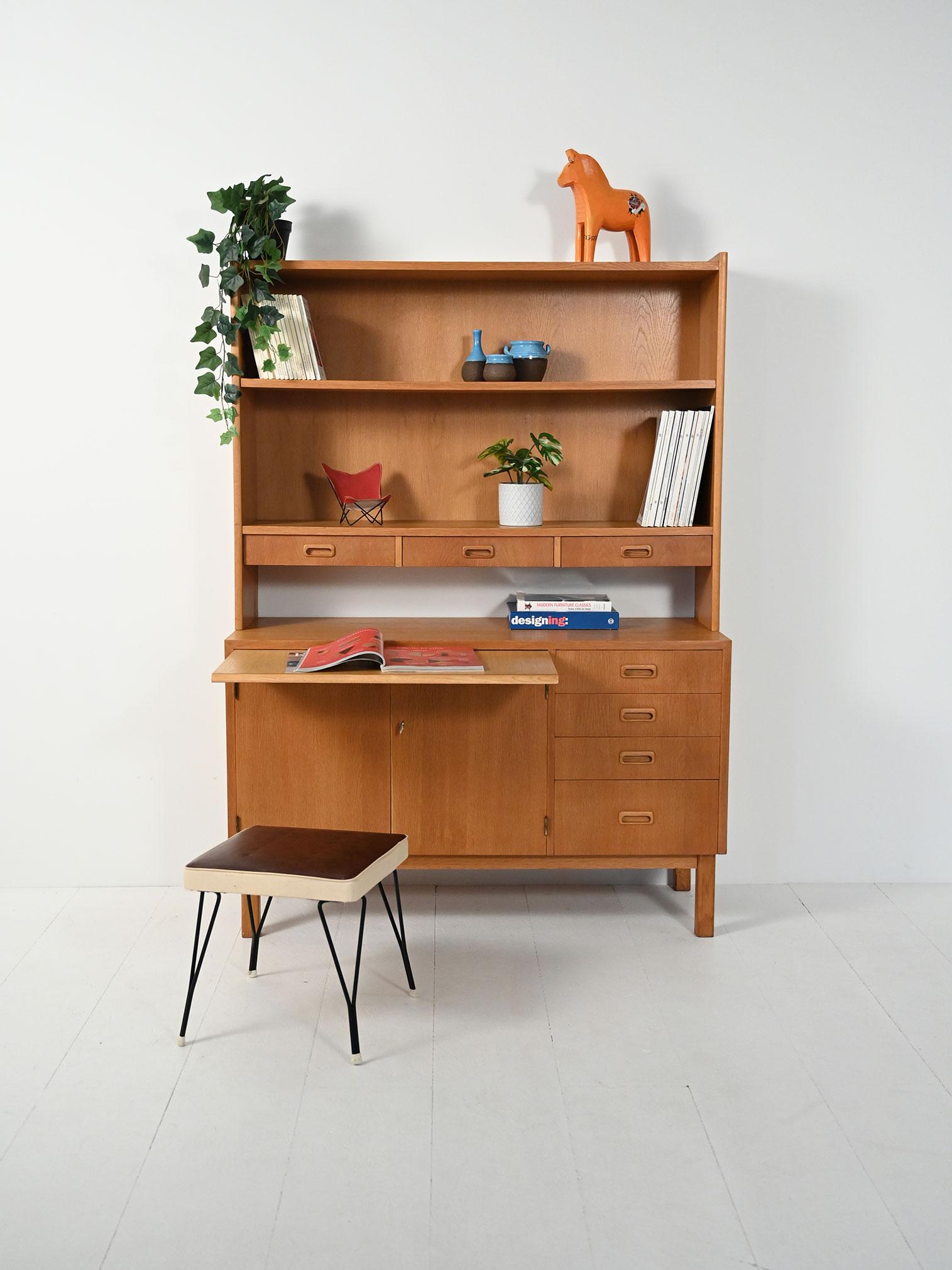 Sideboard con libreria in rovere: solida struttura geometrica, vano con ante e mensola interna, cassetti laterali, scrivania estraibile e mensole a vista.

Sideboard-libreria scandinava in rovere, impostazione rigorosa e proporzioni leggere proprie