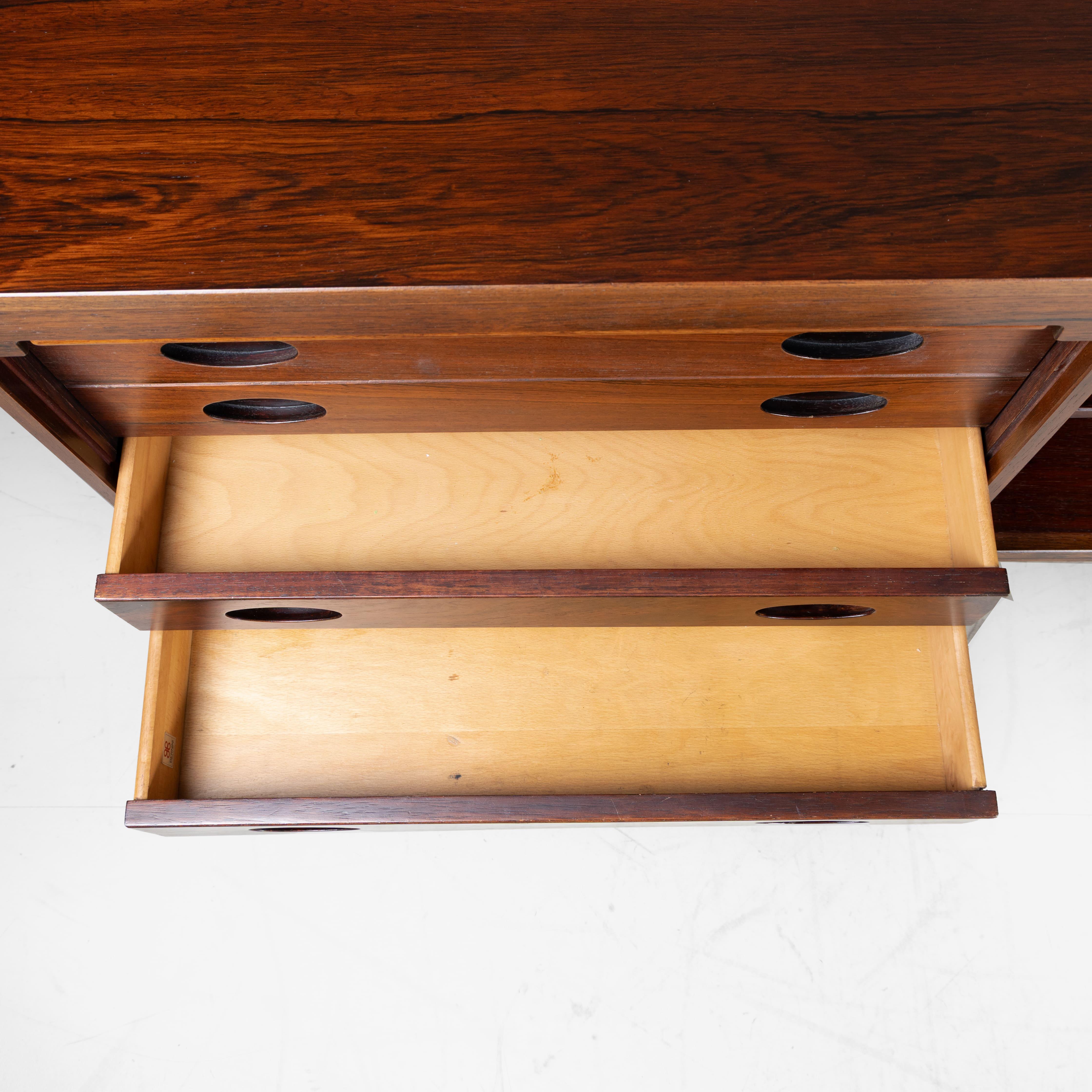 The M501 Credenza, designed by Gianfranco Frattini for Bernini in 1960, is a symbol of elegance and functionality. This extraordinary piece, made of rosewood, is characterized by its sliding shutters that conceal the interior compartments while