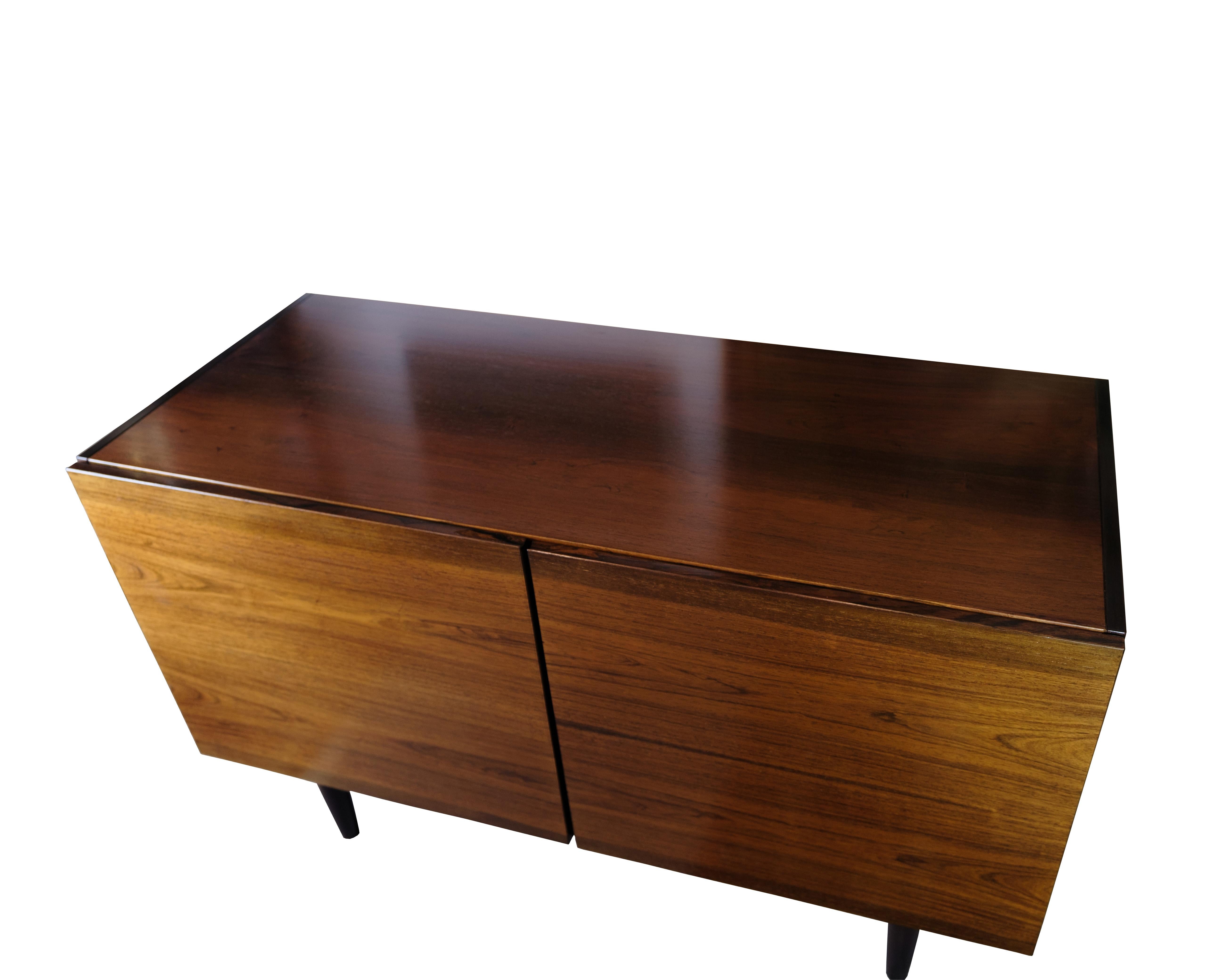 This sideboard in rosewood represents the timeless elegance and functionality that characterizes Danish design from the 1960s. With its two doors and shelf options inside, the sideboard offers both style and practical storage space.

The warm tone