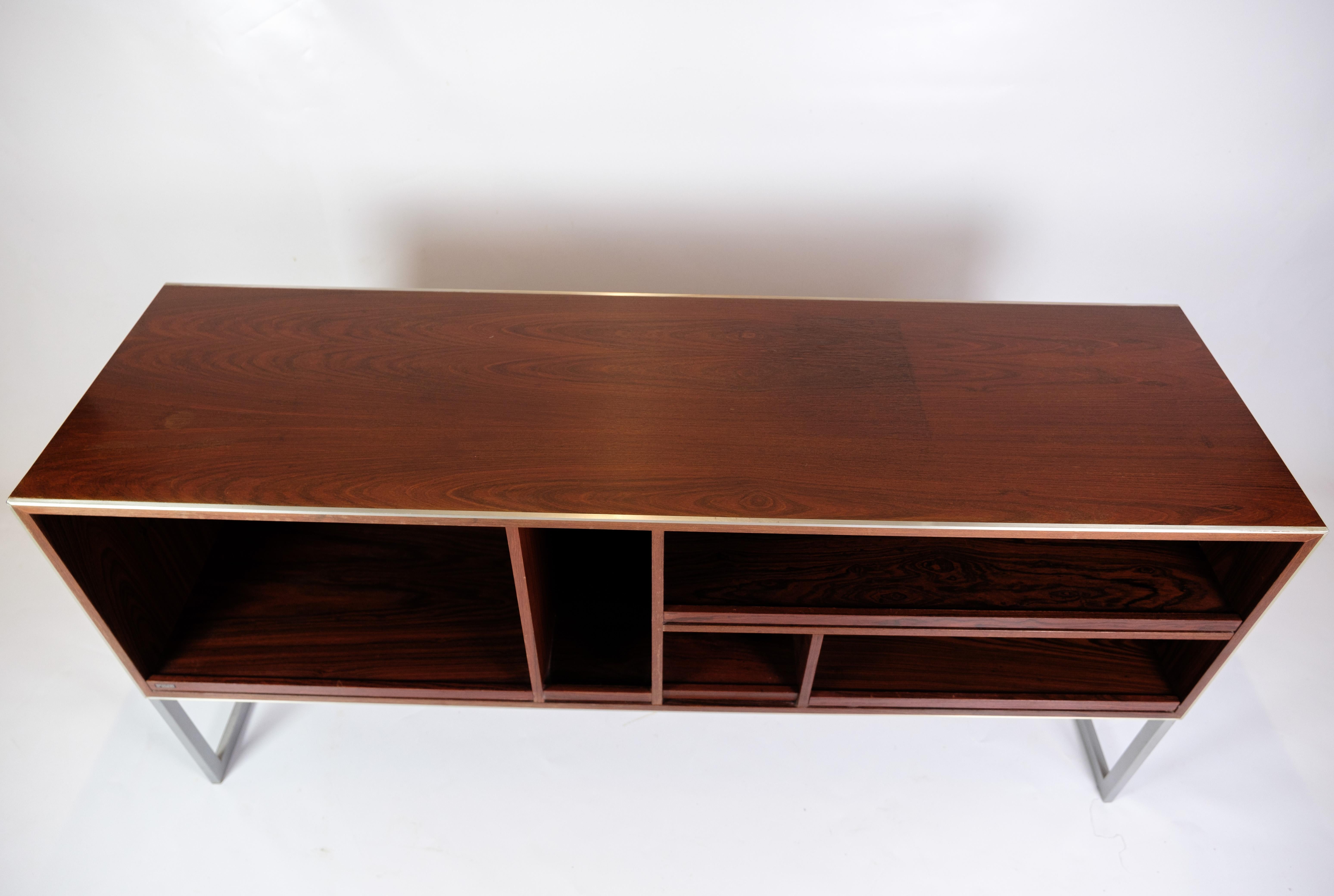 Stereo bench/sideboard in rosewood with metal frame, designed by Jacob Jensen for Bang & Olufsen in the 1970s. This elegant sideboard combines beautiful rosewood with a slim metal frame, giving it a minimalist and timeless look.

Jacob Jensen, known