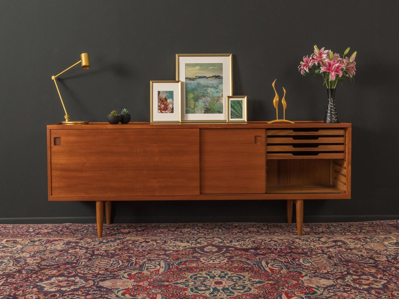 Classic sideboard from the 1960s. Model 20 by Niels O. Møller for his own furniture production company JL Møllers Møbelfabrik. Corpus in teak veneer with two sliding doors, four internal drawers, two shelves and cigar shaped legs .

Quality