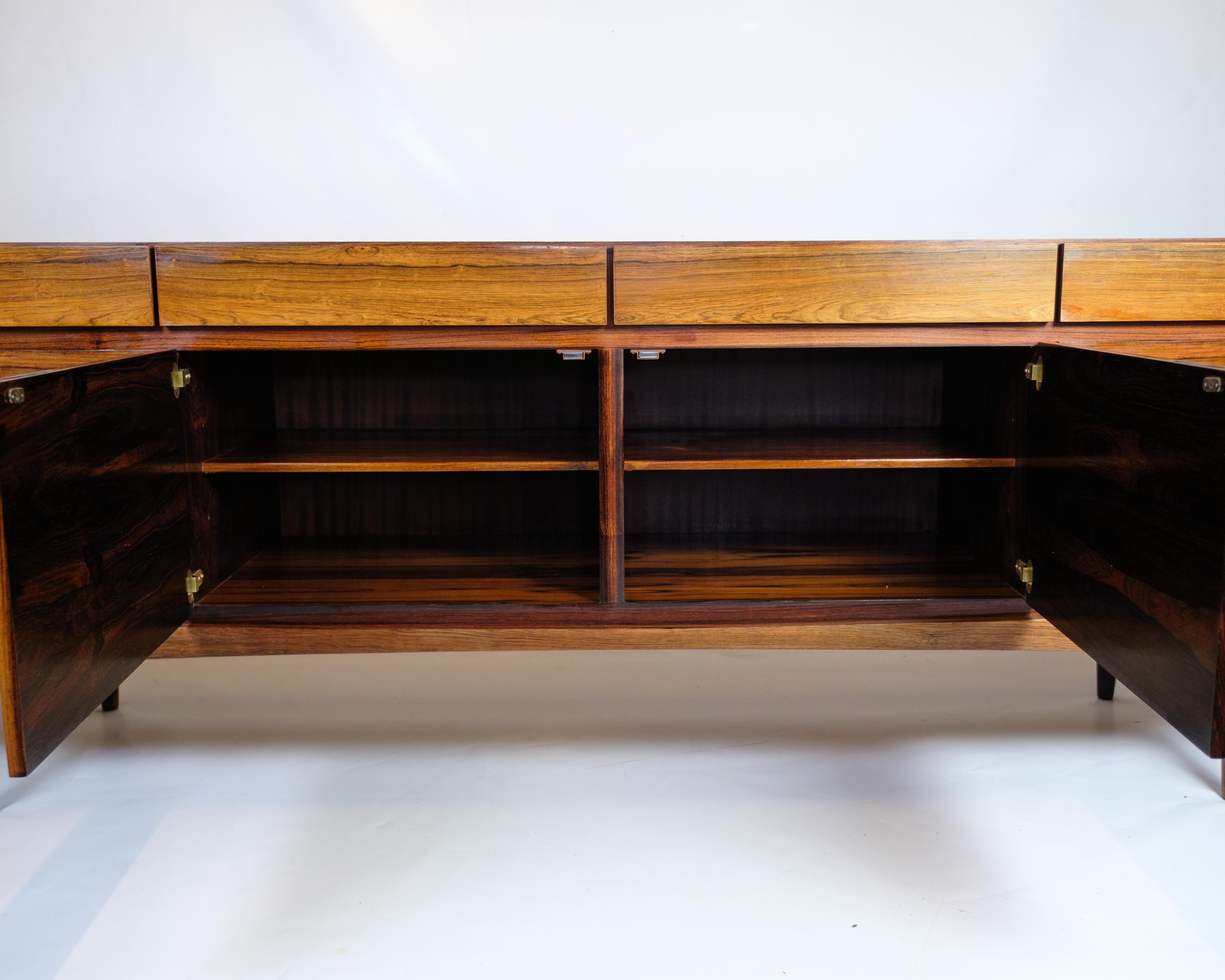 Sideboard designed by Ib Kofod-Larsen, model FA66, produced by Faarup Møbelfabrik in the 1960s. The sideboard is made of rosewood with a beautiful grain pattern and a front with four sliding doors and a drawer section behind one door.

Material: