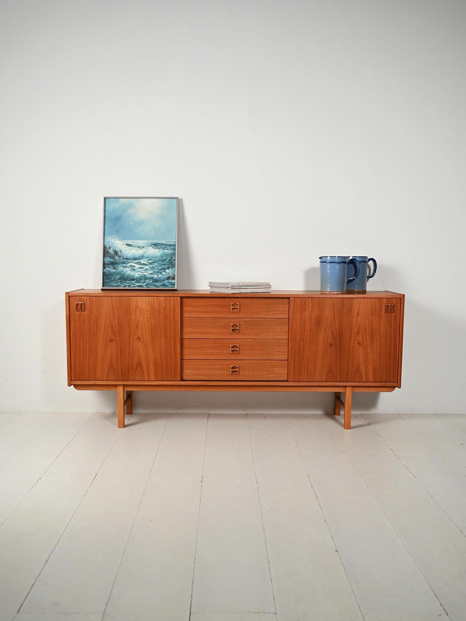 Sideboard scandinavo di IKEA modello Kørsor in teak con ante scorrevoli e cassetti centrali, anni ’60.

Sideboard scandinavo di IKEA modello Kørsor, realizzato in teak negli anni ’60. Il mobile presenta due ante laterali scorrevoli che nascondono