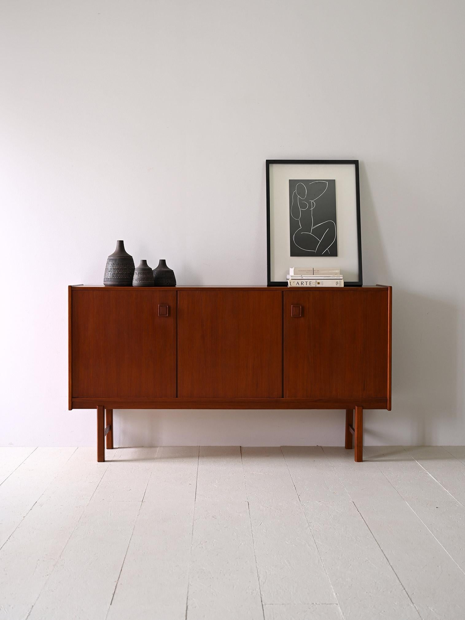 1950s sideboard of Nordic manufacture.

Simple and classic lines for this vintage sideboard with three hinged doors.
It consists internally of two separate compartments, one equipped with shelves and the other with two small drawers and a storage