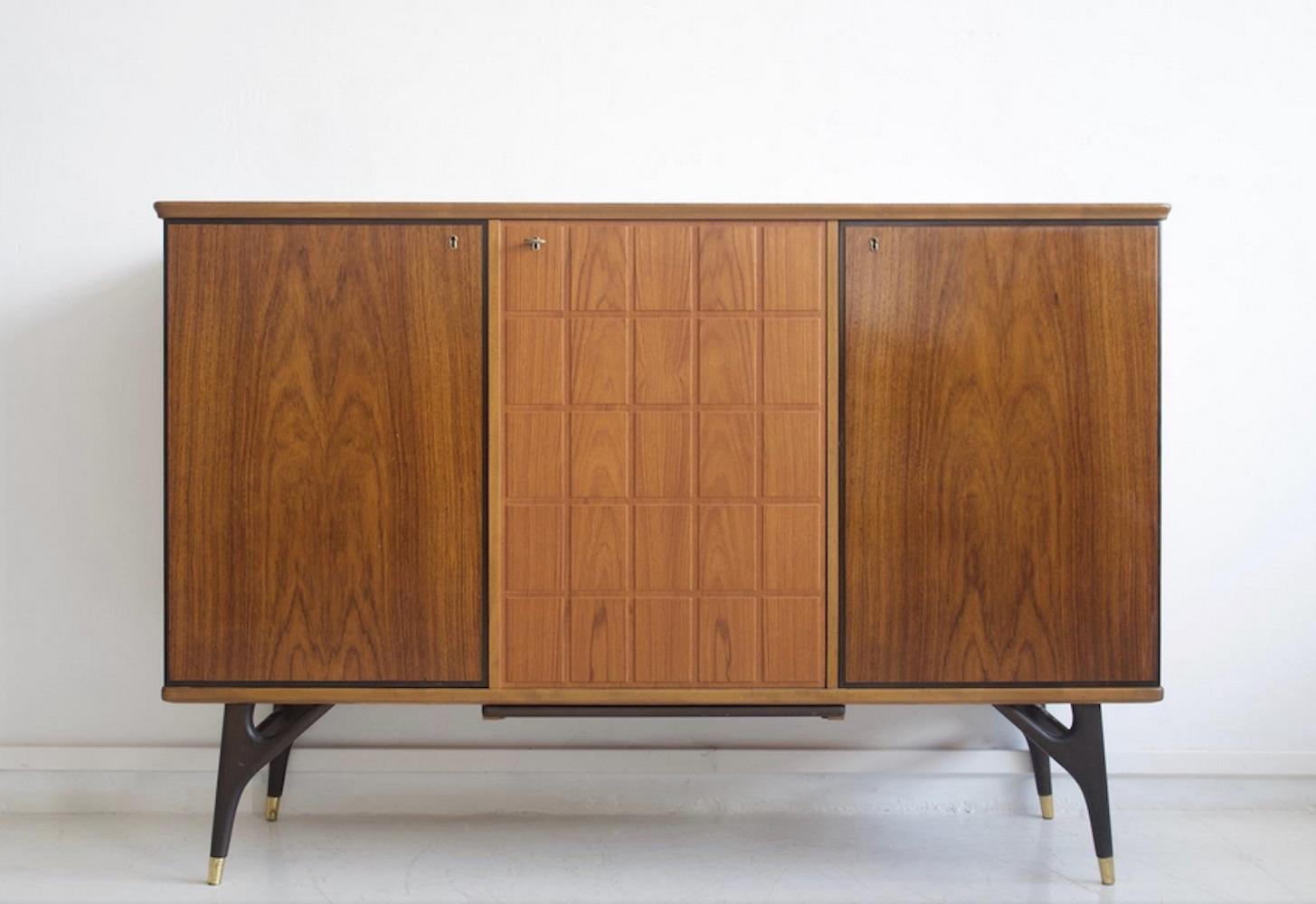 Sideboard veneered with partly stained beech and teak from circa 1950-1960. Manufactured by Tabergs Mobler. Legs with brass braces. Three doors, interior drawers and shelves. Key included. Good vintage condition, minor marks as seen on photos.