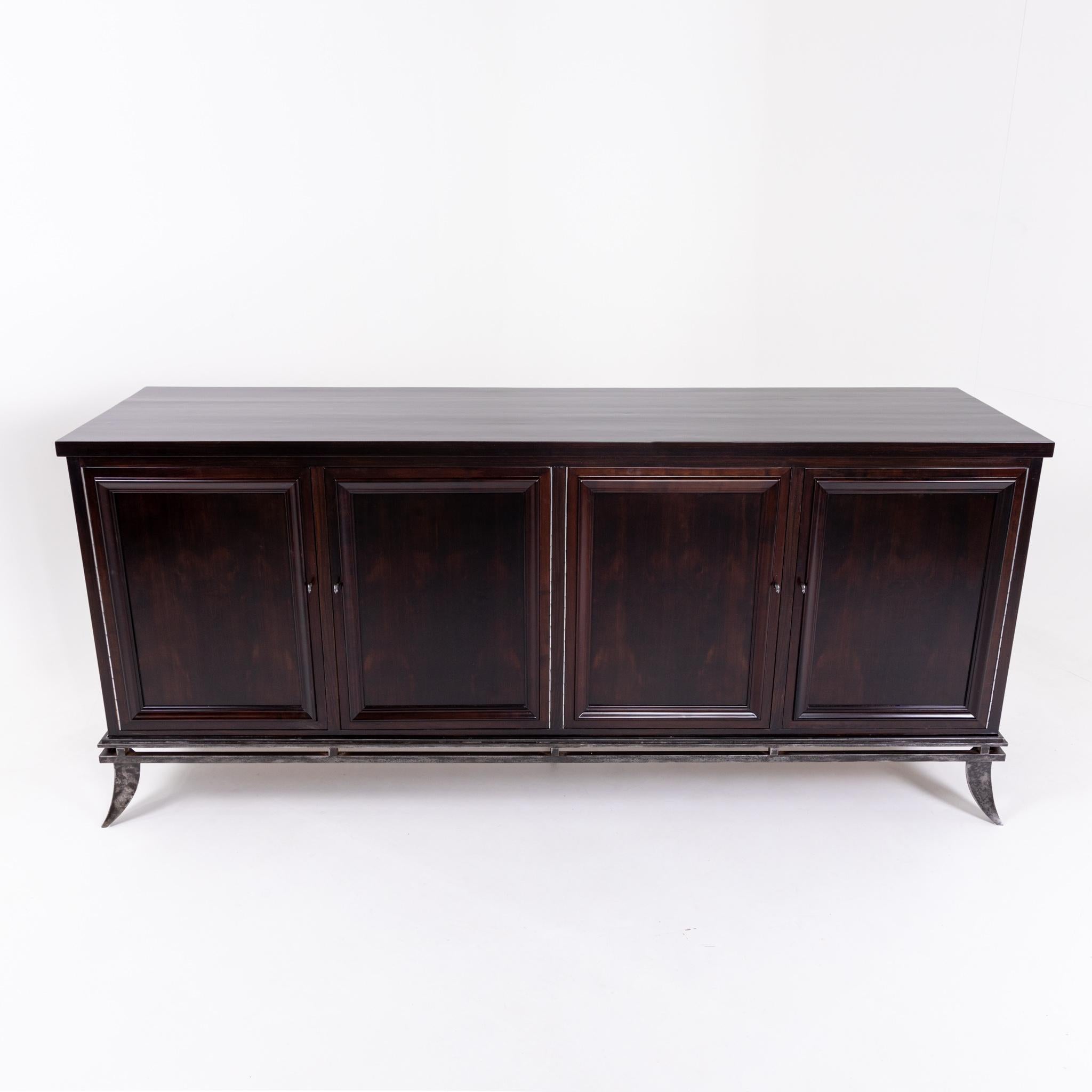 Four-door sideboard on elegant iron frame with flared saber legs. Interior partition consists of shelves and drawers.