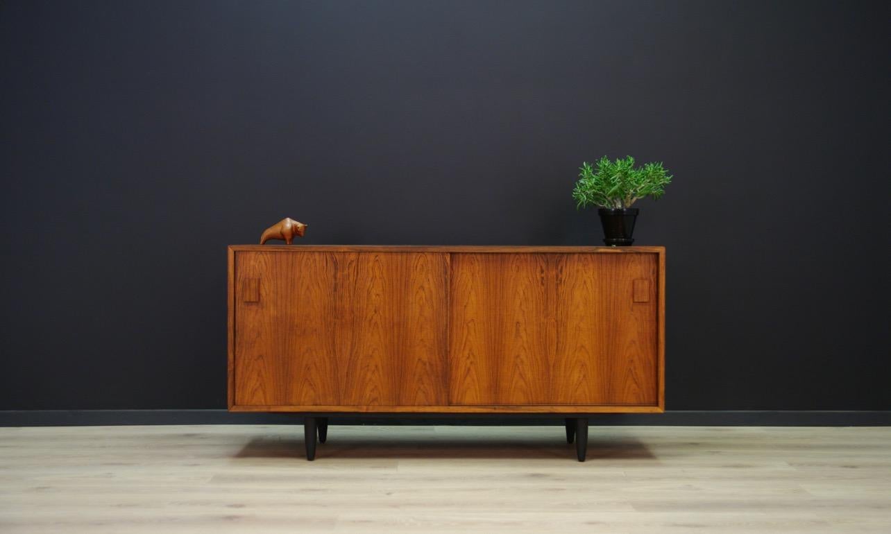 Sideboard from the 1960s-1970s, beautiful Danish design. The surface is veneered with rosewood, item has a roomy interior with shelves and drawers behind the sliding doors. In the right section, two cable holes. Preserved in good condition (small