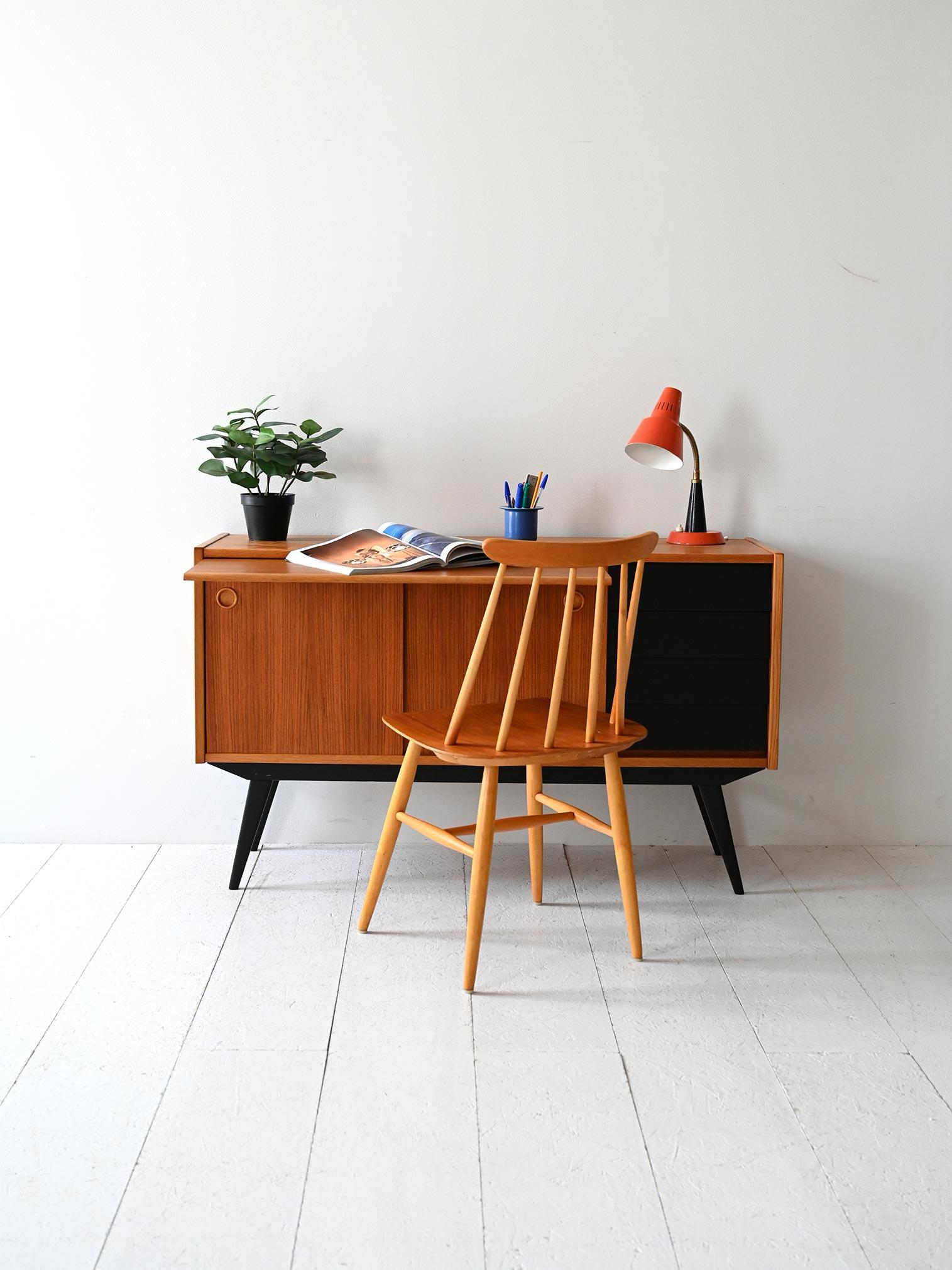 Sideboard anni ’50/’60 in teak con gambe e cassetti neri, scrivania estraibile, ante scorrevoli e vano interno.

Sideboard scandinavo originale anni ’50/’60 in teak, con scrivania estraibile integrata. Il corpo centrale include ante scorrevoli con