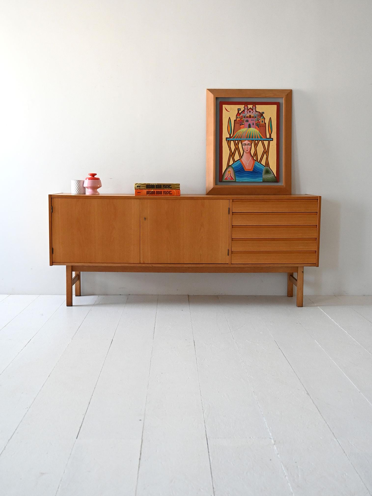 Sideboard in rovere con ante a battente e cassetti laterali a latta dal design pulito e geometrico tipico degli anni ’60/’70.

Sideboard scandinavo in rovere realizzato negli anni ’60/’70, caratterizzato da linee sobrie e struttura equilibrata. Le
