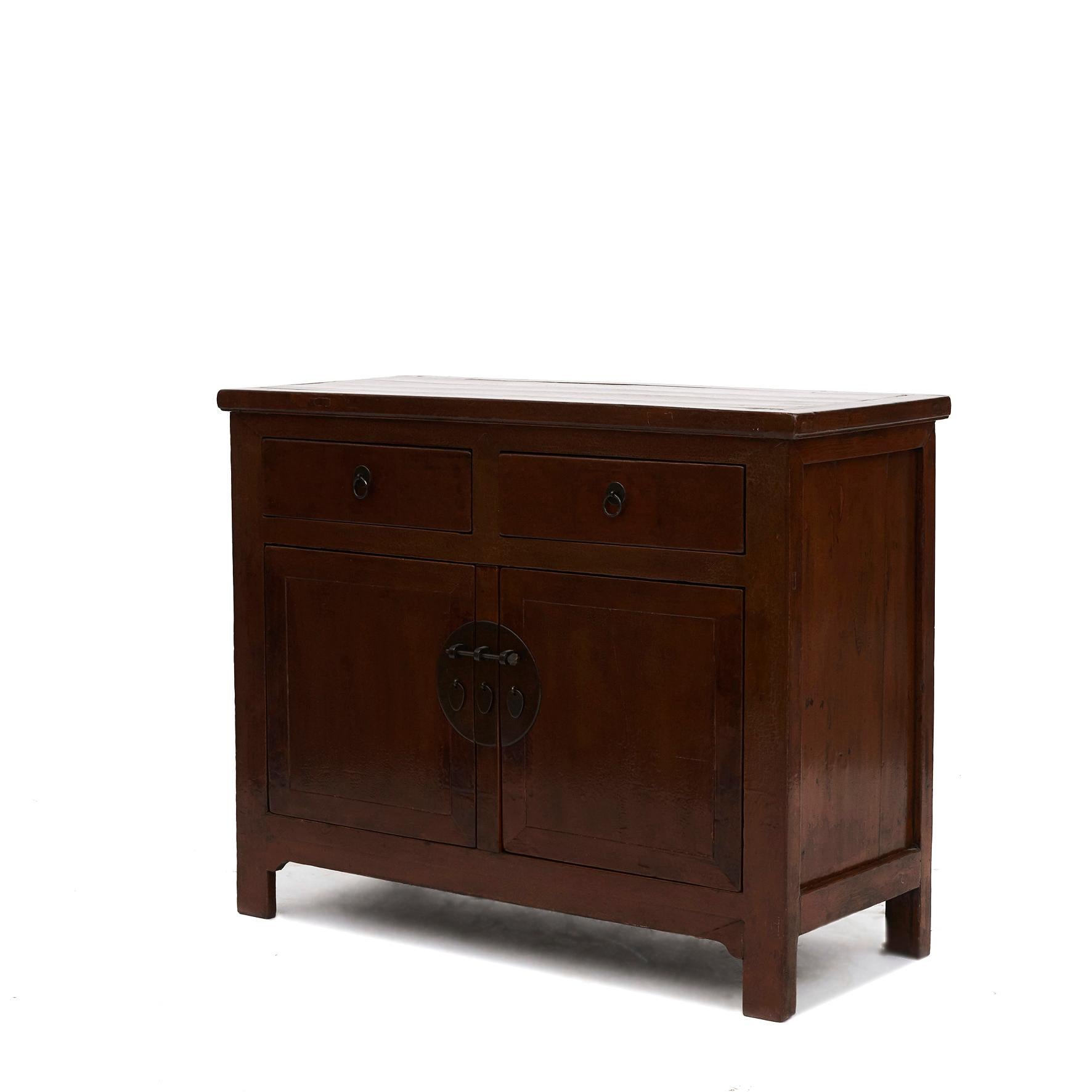 Sideboard in an original beautiful nut colored lacquer with a good patina.
Two drawers under which a pair doors with a central bar.

If needed the center bar can easily be removed to make it easy to place a wider item into the cabinet

From