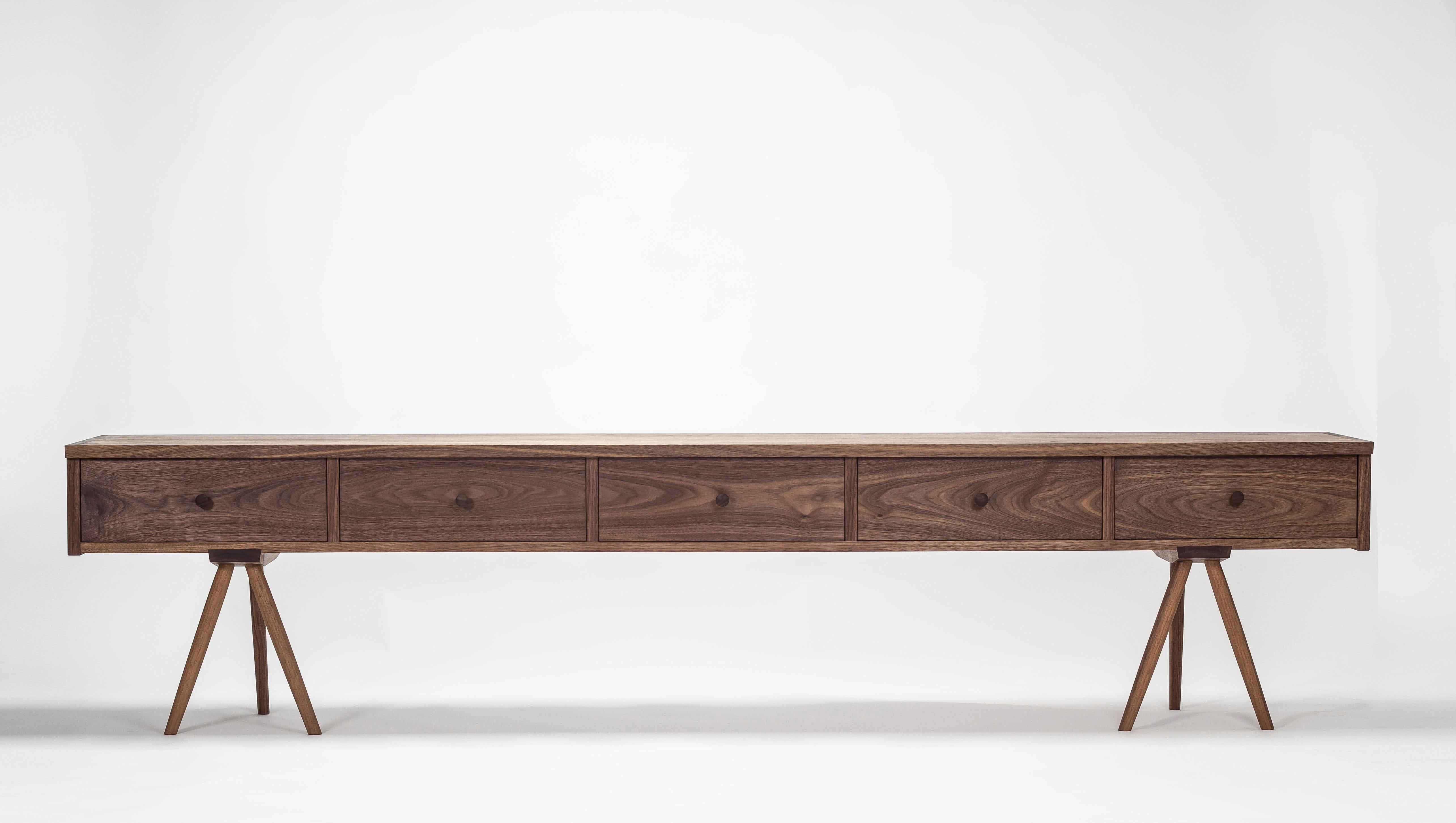 A solid black walnut sideboard/credenza with drawer bottoms made of solid oak or maple. It is made by Master craftsman and artist Frank Buschmann with great attention to detail, such as having the drawer fronts made from a single piece to ensure a