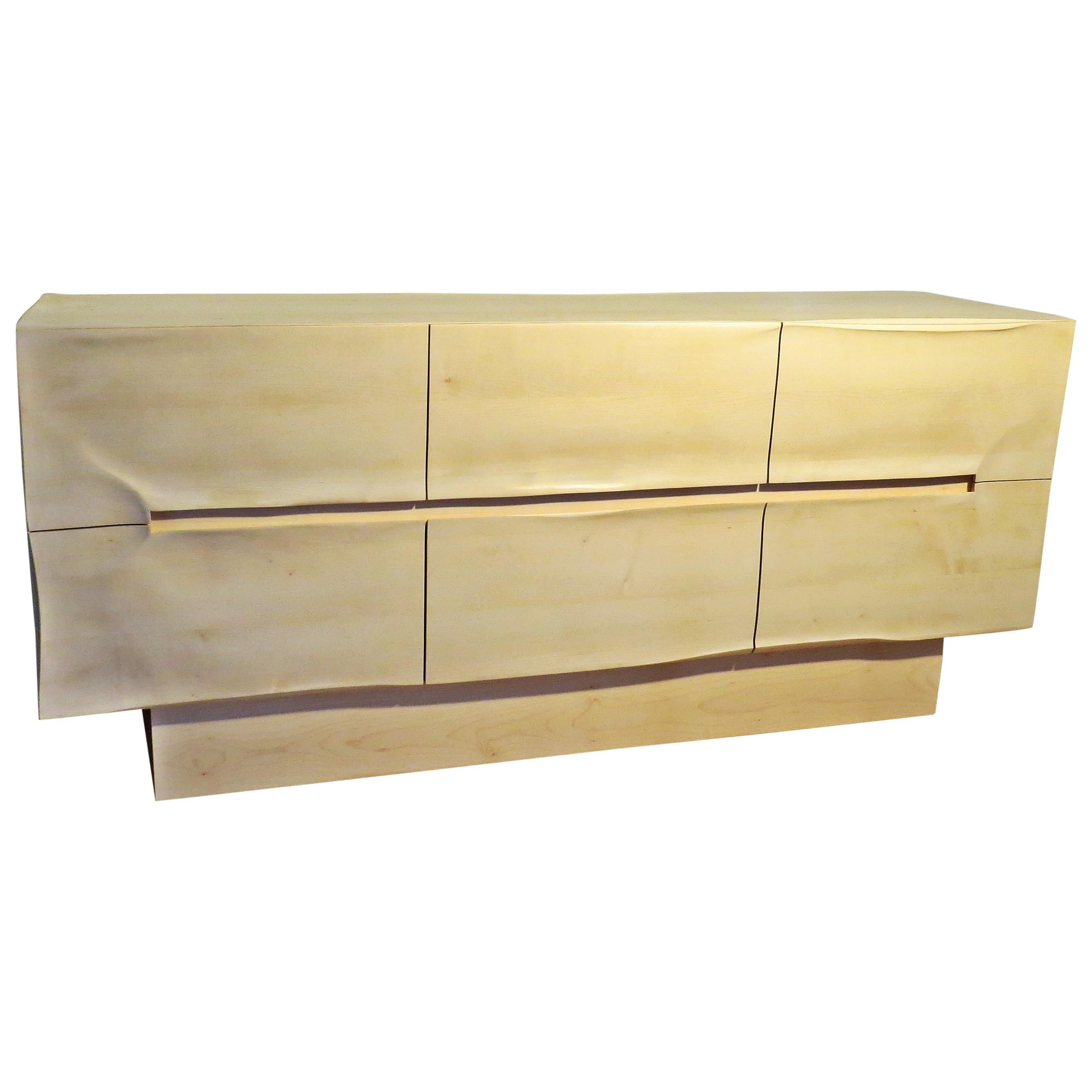 These sideboards are made by hand in organic design.
The furniture is very sculptural but modern, through the surfaces with wrinkles and bumps creates a play with light and shadow.
The grip section is integrated and incorporated into the