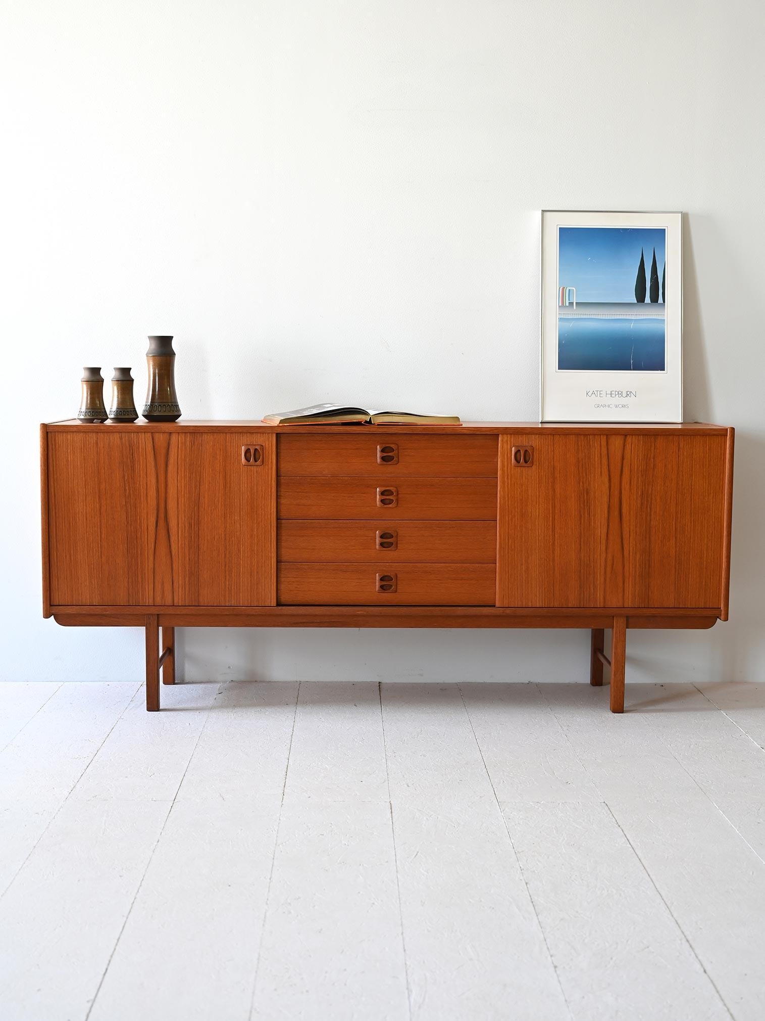 Credenza di modernariato con cassetti centrali e ante scorrevoli laterali. Le impugnature scolpite nel legno sono tipiche del design nordico del XX Secolo. 

Ideale come mobile tv ma anche per arredare altri spazi della casa in perfetto stile