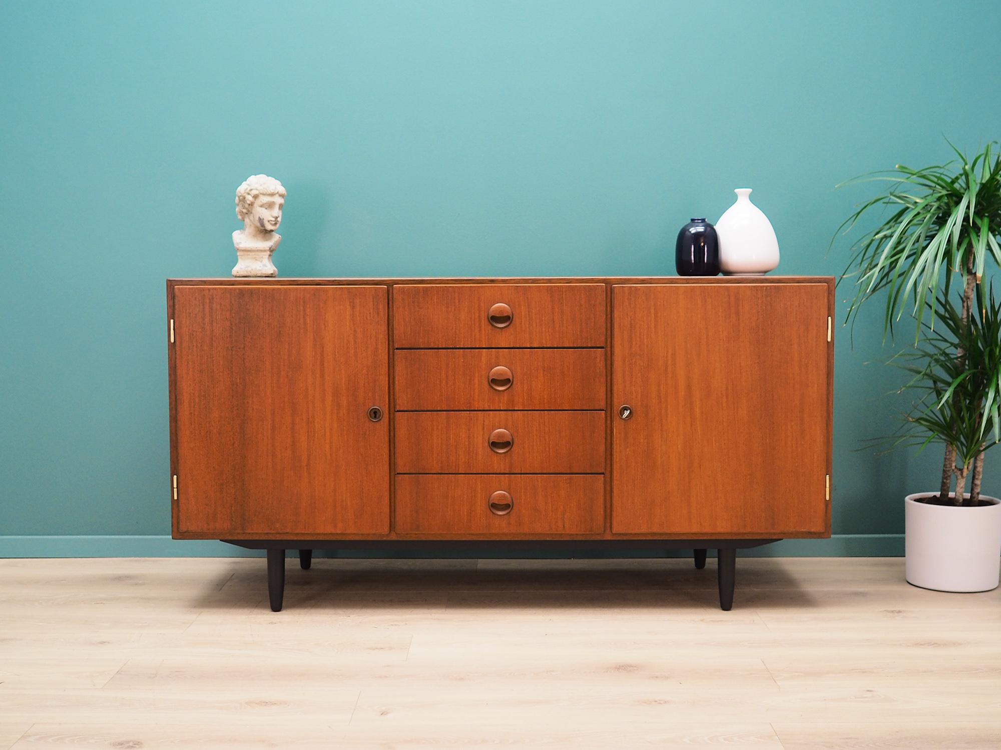 Sideboard was made in the 1960s, Danish production.

The structure is covered with teak veneer. Legs made of solid wood stained black. Surface after refreshing. Inside the space has been filled with practical shelves, shelves with height