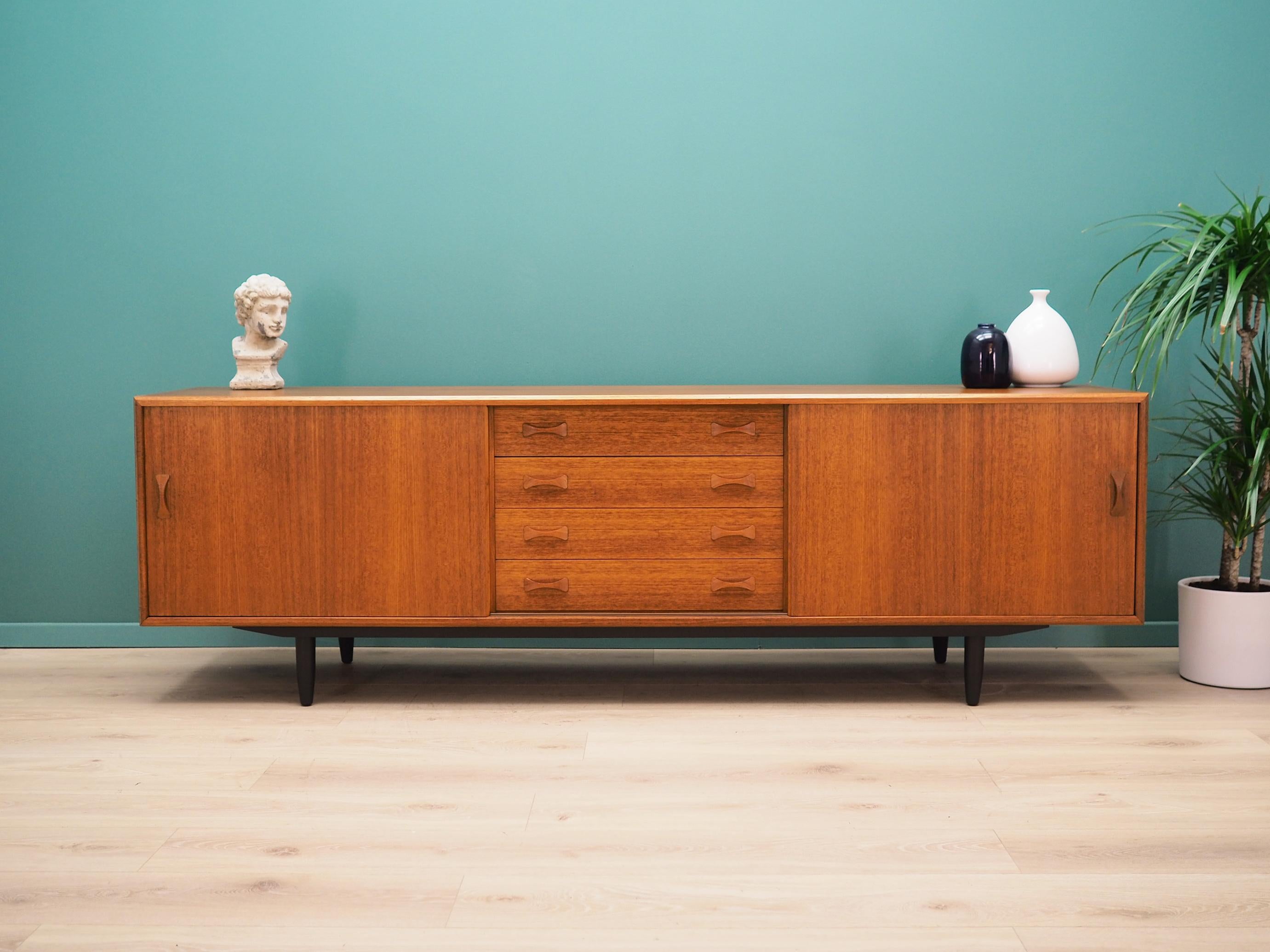 Sideboard was made in the 1960s by a well-known Danish manufacturer Clausen & Søn.

The structure is covered with teak veneer. The legs are made of solid wood stained black. Surface after refreshing. Inside the space has been filled with practical