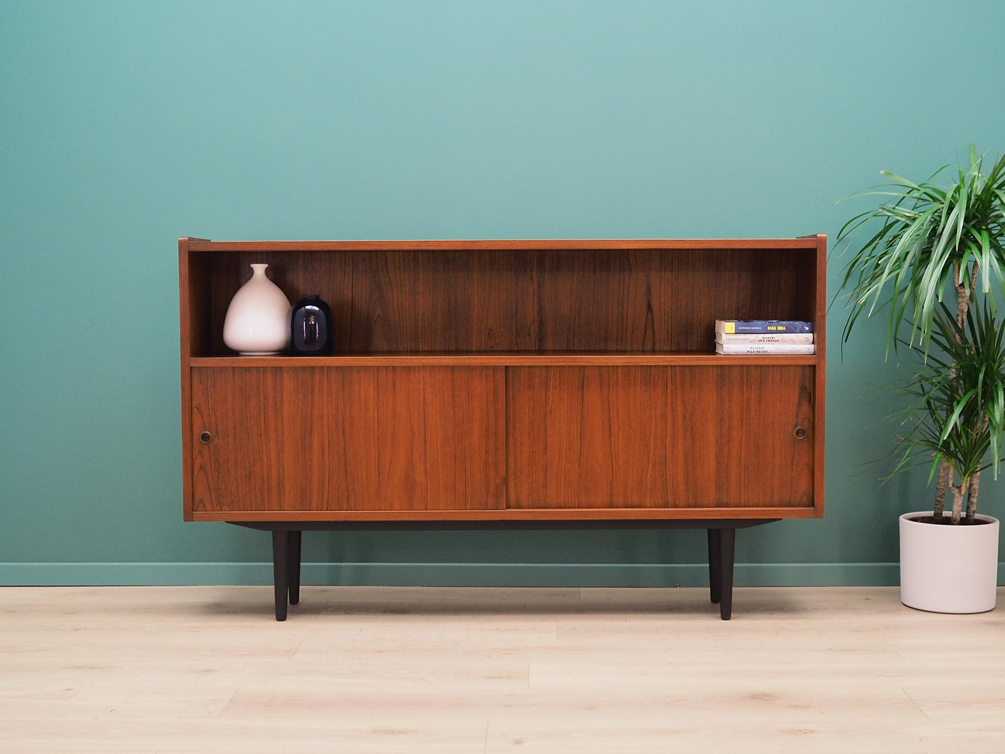 Sideboard was made in the 1970s, Danish production.

The structure is covered with teak veneer. Legs made of solid wood stained black. Surface after refreshing. Inside the space has been filled with a practical shelf with no height adjustment. The