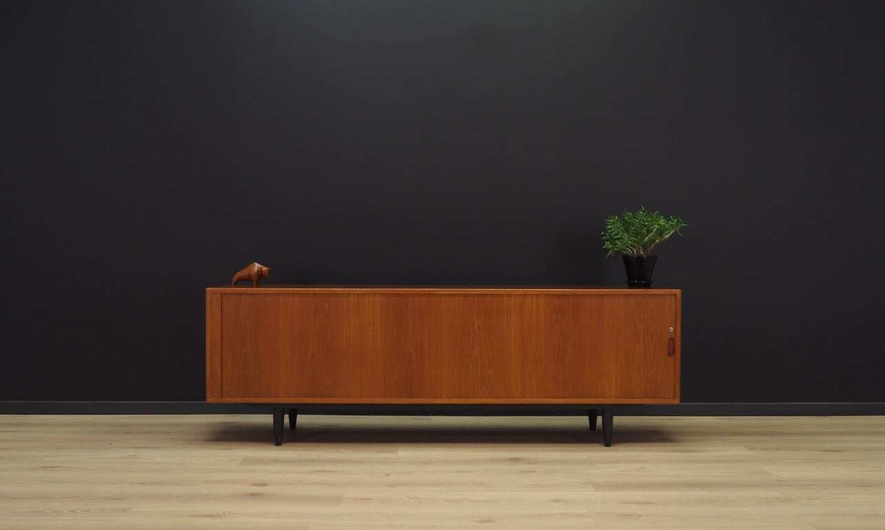 Phenomenal sideboard from the 1960s-1970s, Scandinavian precision and attention to detail. Furniture veneered with teak. In the interior, behind the folding doors there are two-shelves with the possibility of adjustment. No key in the set. Preserved