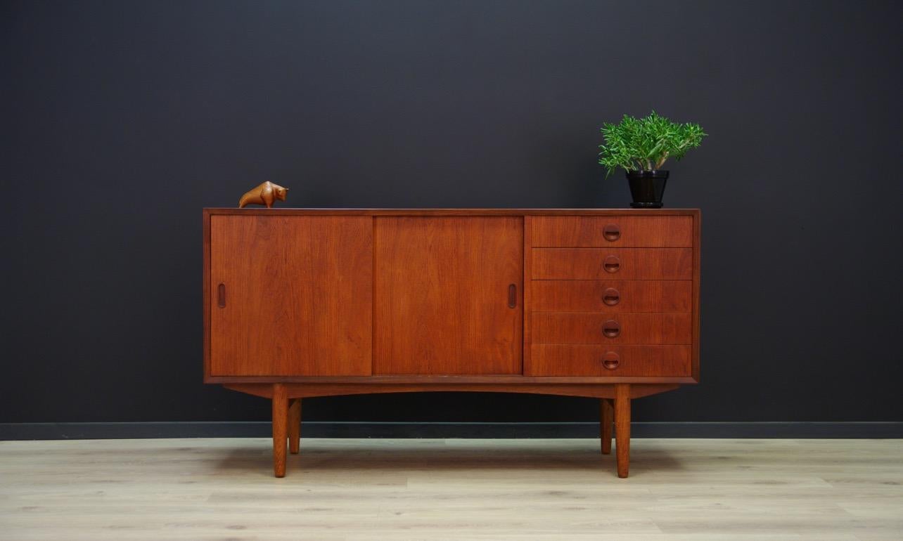 Stylish sideboard from the 1960s-1970s, Danish design. Furniture veneered with teak. In the right section there are five utility drawers, behind the slidings doors, a shelf. Preserved in good condition (small bruises and scratches), directly for