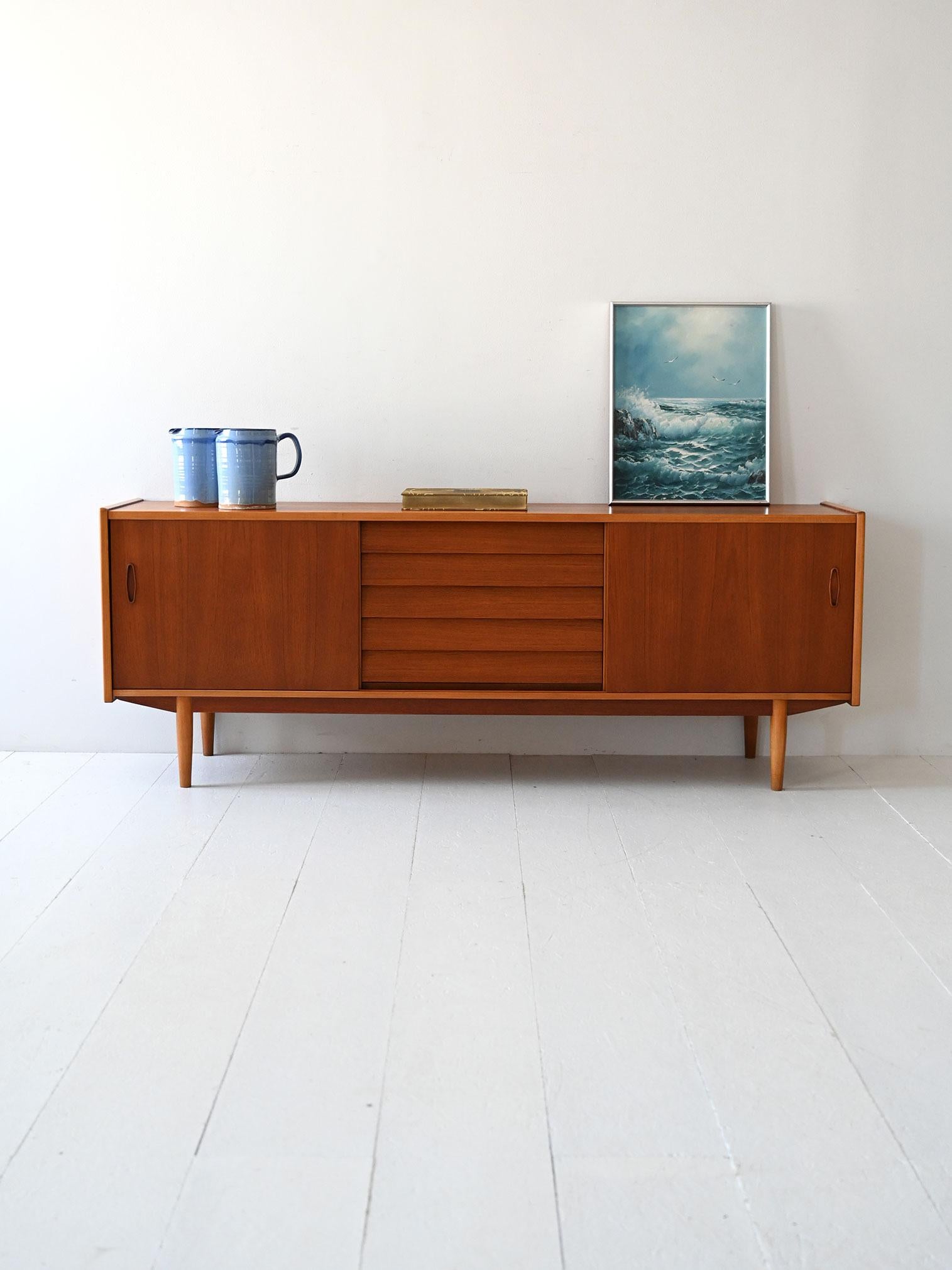 Sideboard scandinavo modello “Trio” in teak e rovere, disegnato da Nils Jonsson per Hugo Troeds, con cassetti centrali a tegola.

Raro sideboard modello “Trio” disegnato da Nils Jonsson per Hugo Troeds Bjärnum negli anni ’60. Realizzato in teak e