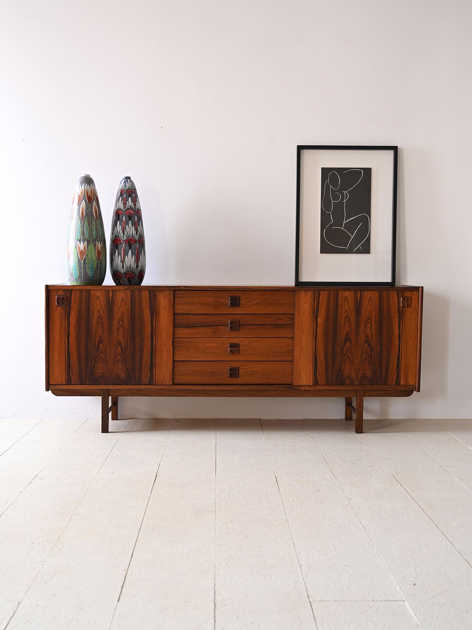 Nordic sideboard made of teak and black painted details. 

On the outside, the sideboard features a balanced and sophisticated design. On the sides, we find a hinged door on each side, both equipped with a lock. In the center, the arrangement is