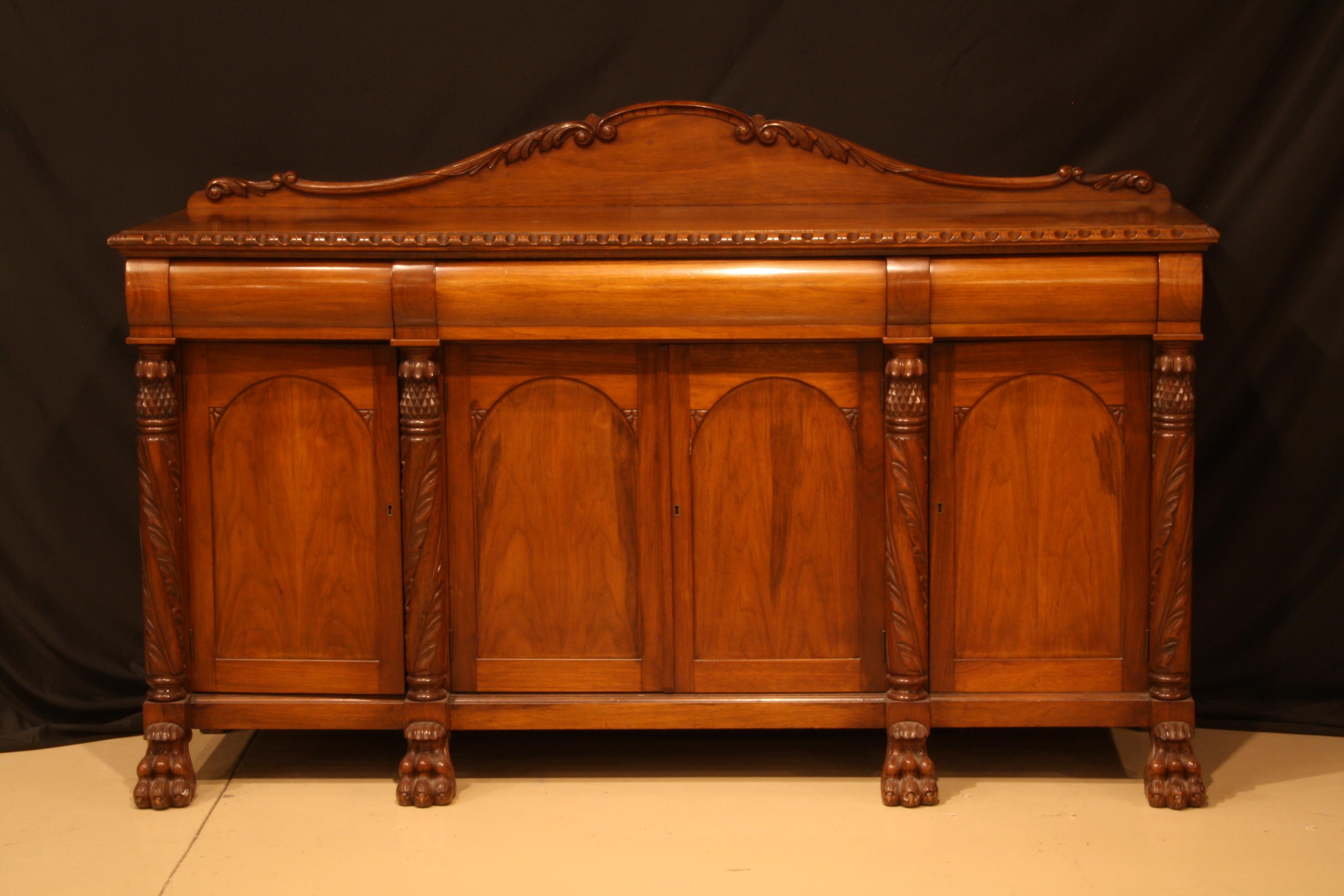 Walnut sideboard three drawers and four doors, carved pillars and back splash.